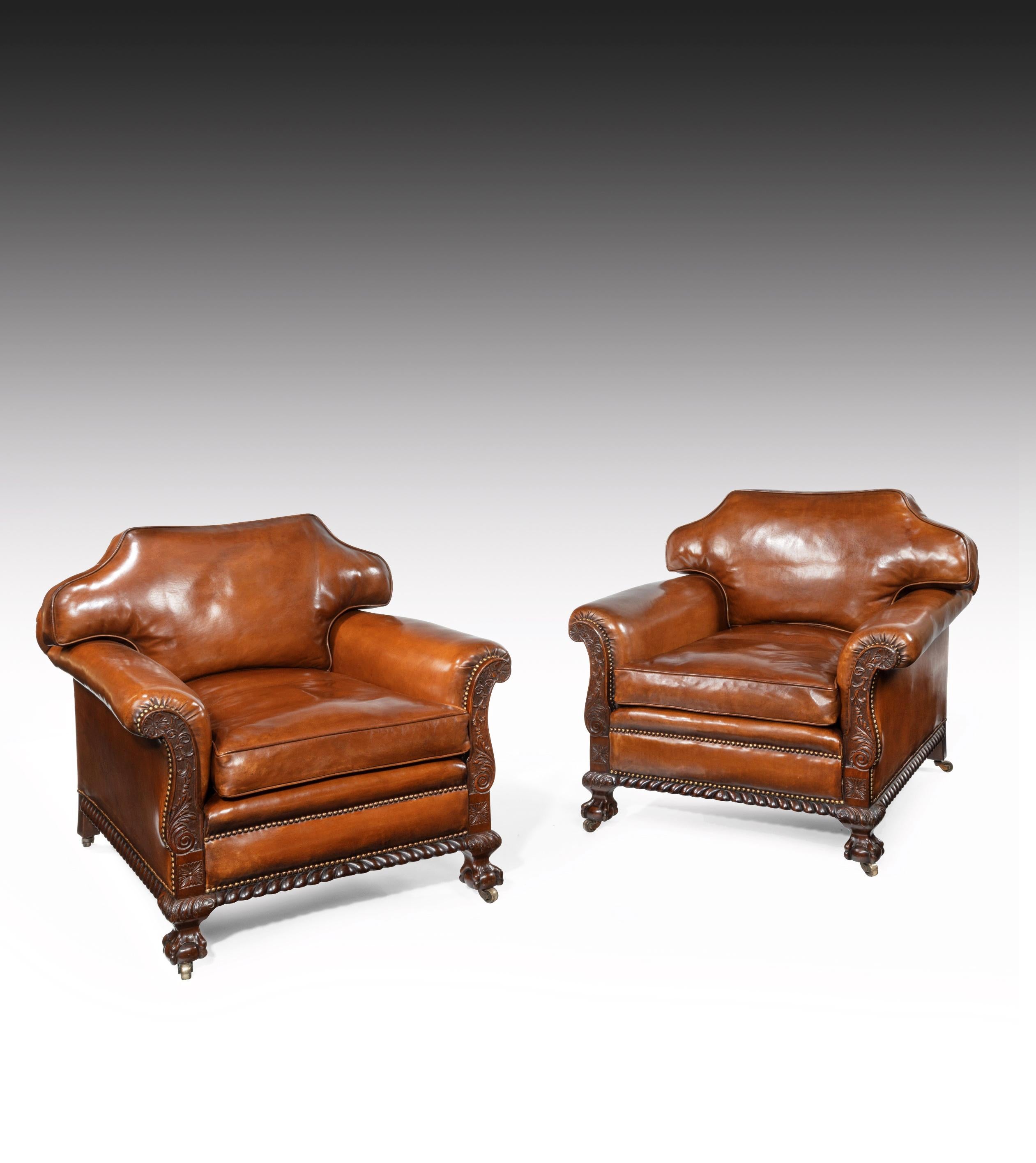 A fine pair of 19th century Victorian carved mahogany country house leather upholstered armchairs of generous proportions.

English, circa 1870.


A handsome pair of antique leather armchairs having the desirable down feathered cushioned back