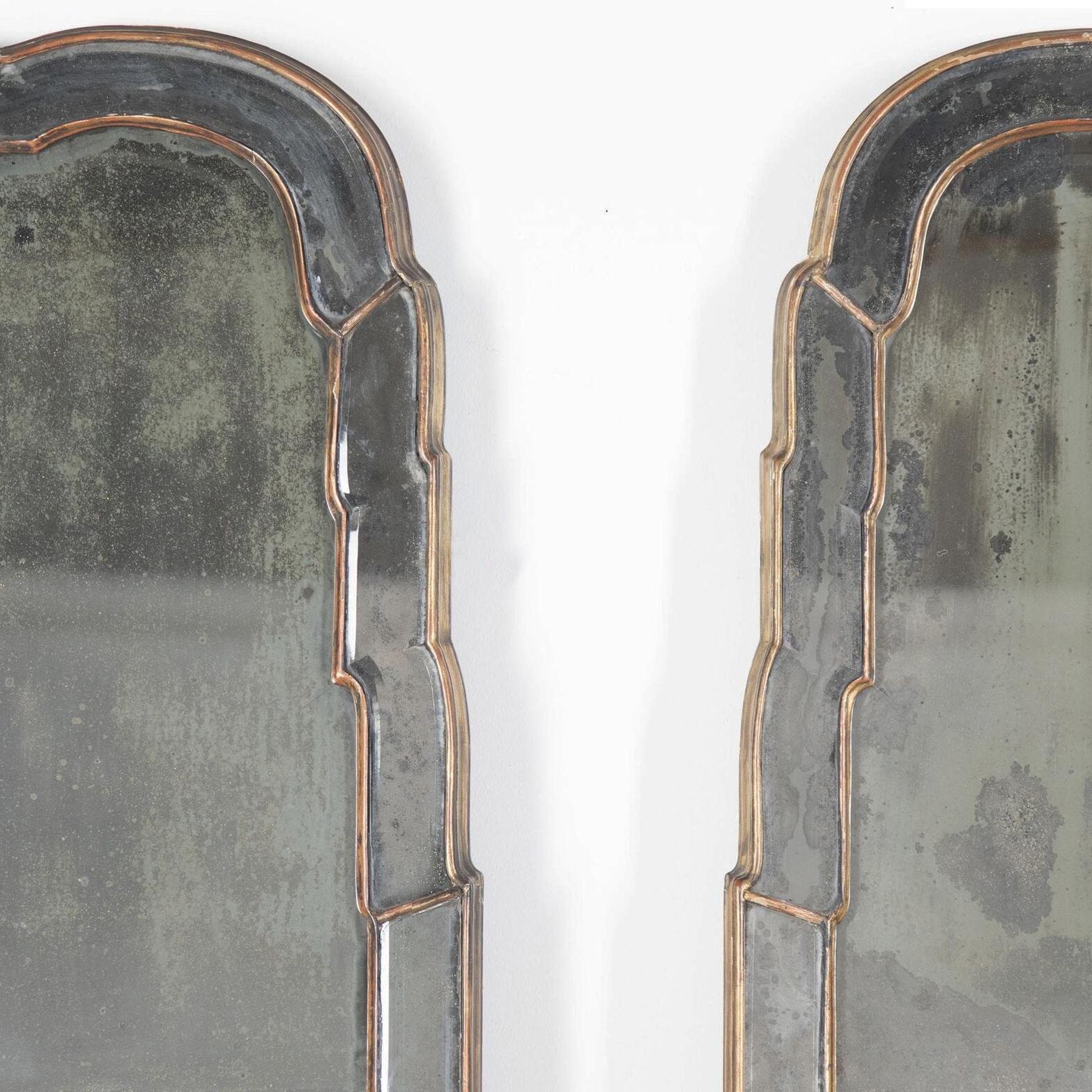 19th century magnificent large pair of Queen Anne style pier mirrors with mirrored border outer slips that are double bevelled that reflect and refracts the light beautifully. 
The double arched divided plates are also hand bevelled and wonderfully