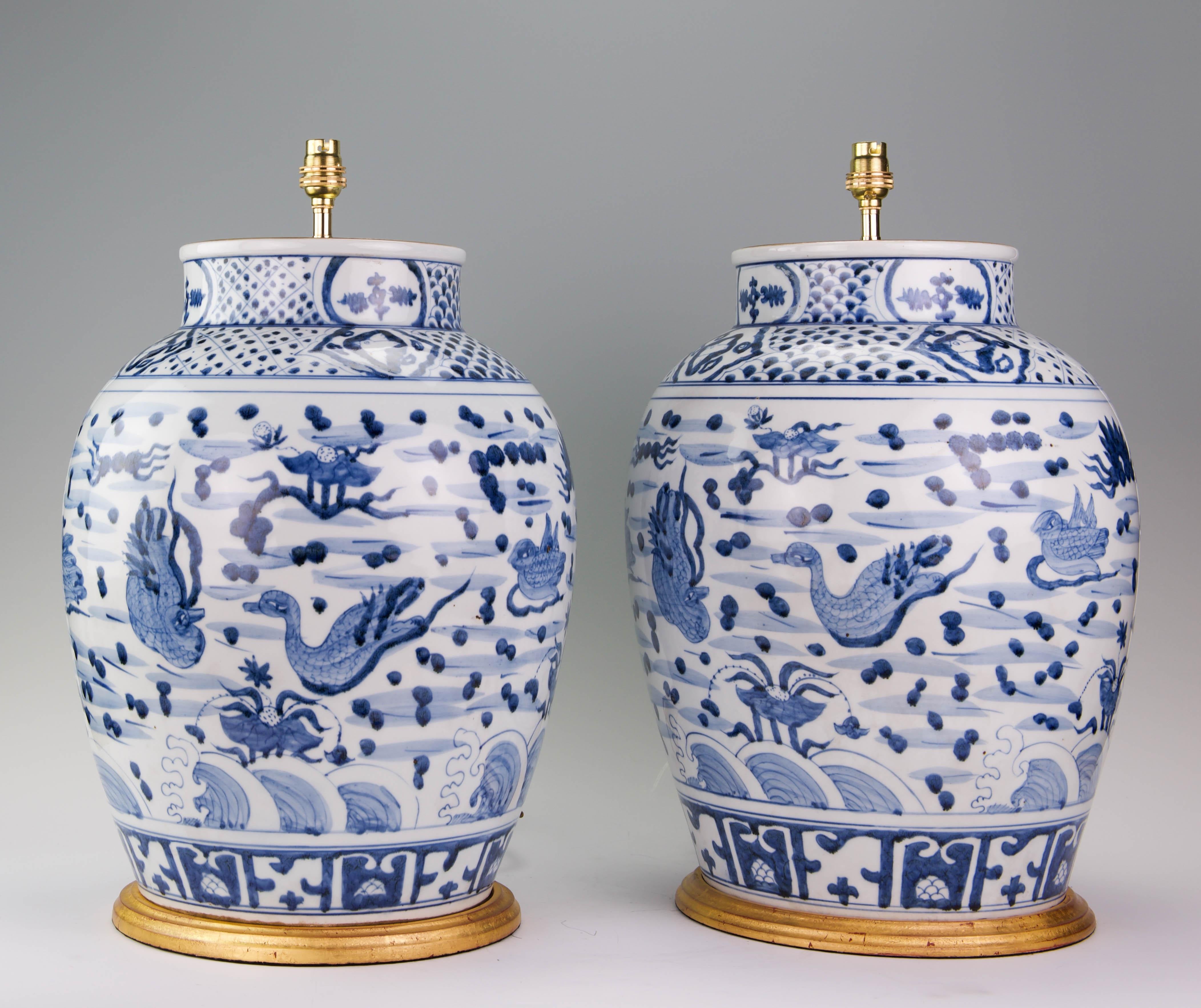 A fine pair of large Chinese blue and white Kangxi style baluster vases, beautifully painted with ducks in a stylised river landscape, now mounted as table lamps with hand gilded tuned bases.

Measures: height of vases: 17 3/4 in (45 cm) including