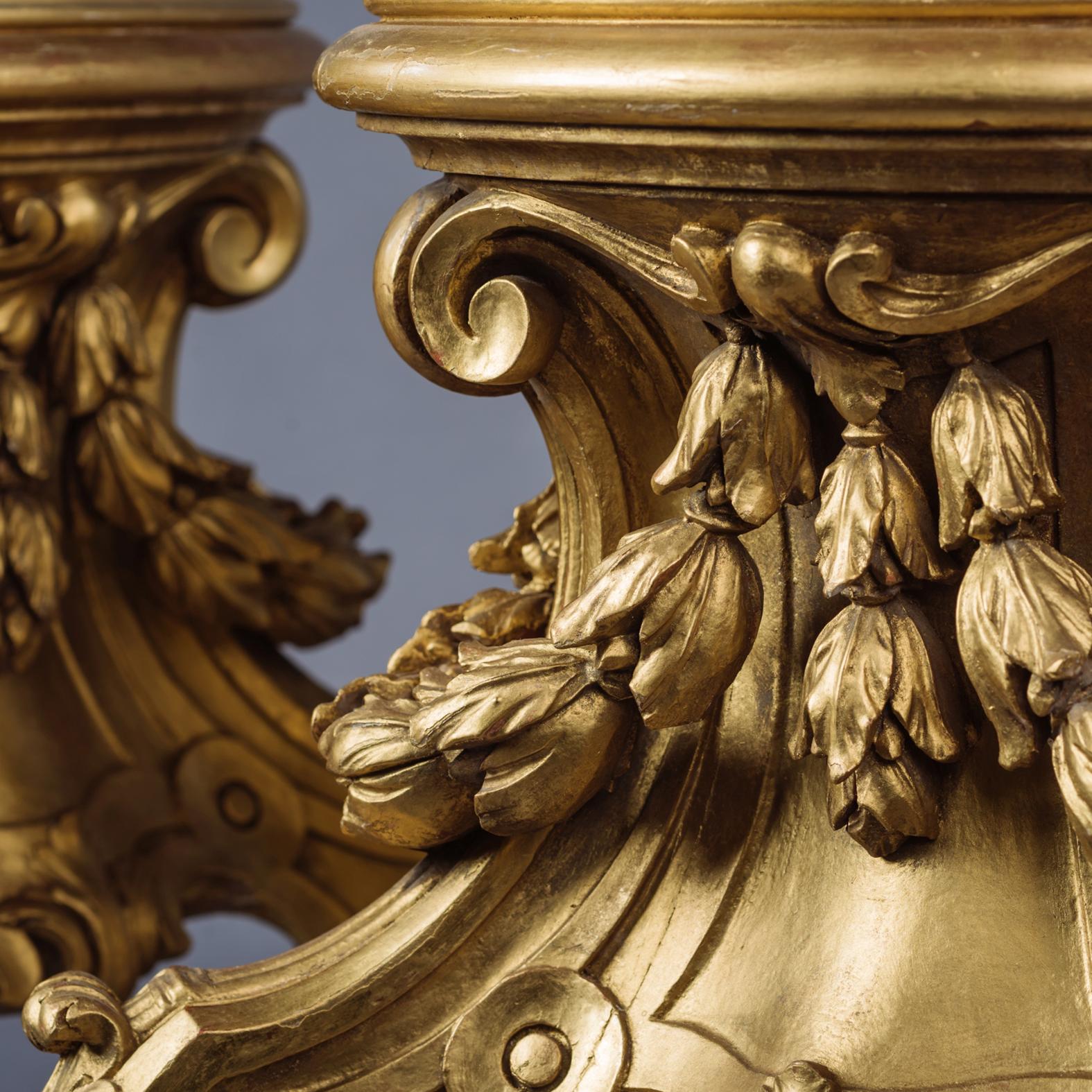 Une grande paire de supports en bois doré sculpté d'acanthes.

Chaque support présente un plateau circulaire en forme de cuvette au-dessus d'une base sculptée d'acanthe avec des coques de clochettes et des pieds sculptés d'acanthe,

Français,