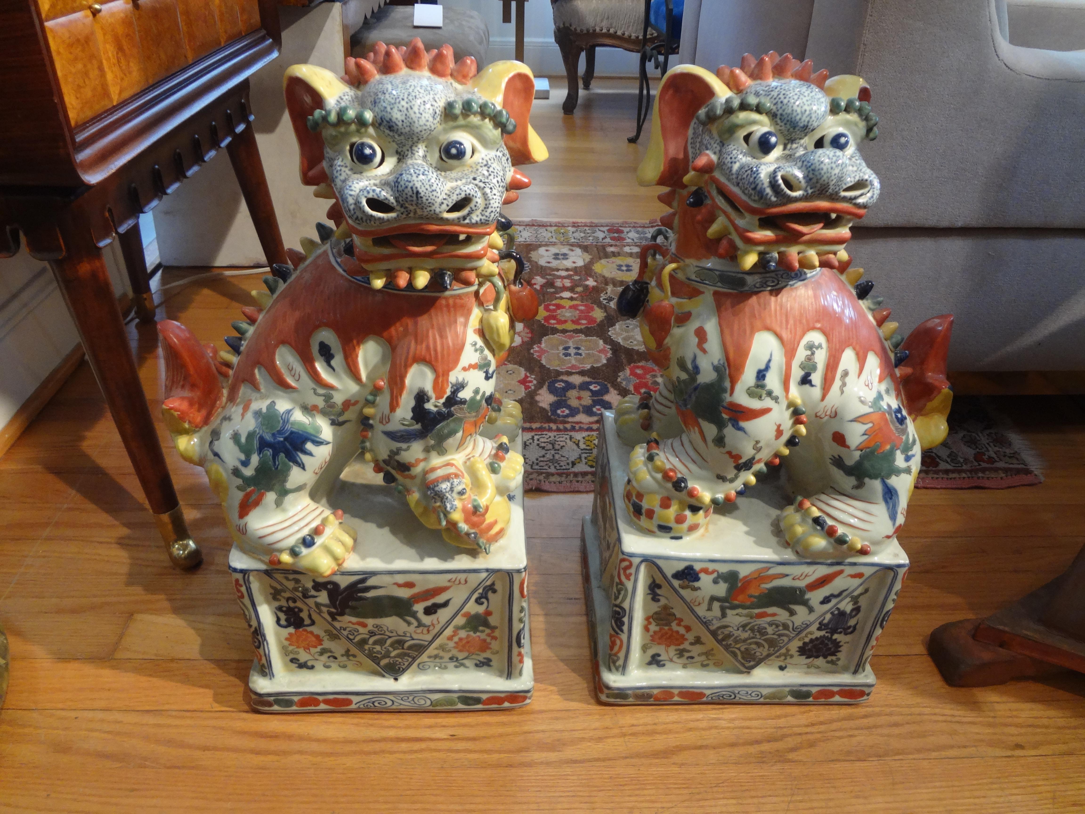 Stunning pair of antique Chinese hand decorated porcelain foo dogs or foo lions. This beautiful pair of Chinese foo dogs are executed in fabulous and unusual colors and date to the 1930s-1940s. They are Artist-signed (see photos).