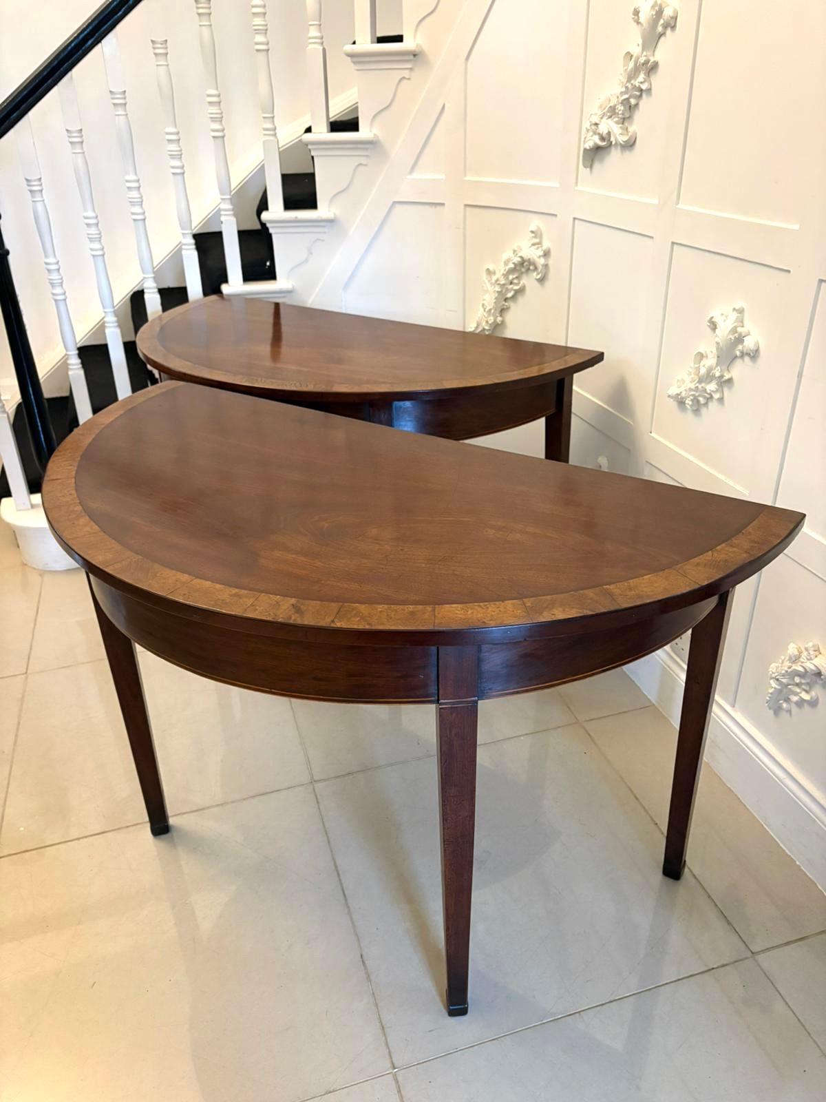 Large pair of antique George III quality figured mahogany Demi lune console tables having a quality figured mahogany satinwood crossbanded demi lune shaped top, mahogany frieze with inlaid satinwood stringing standing on four square tapering legs