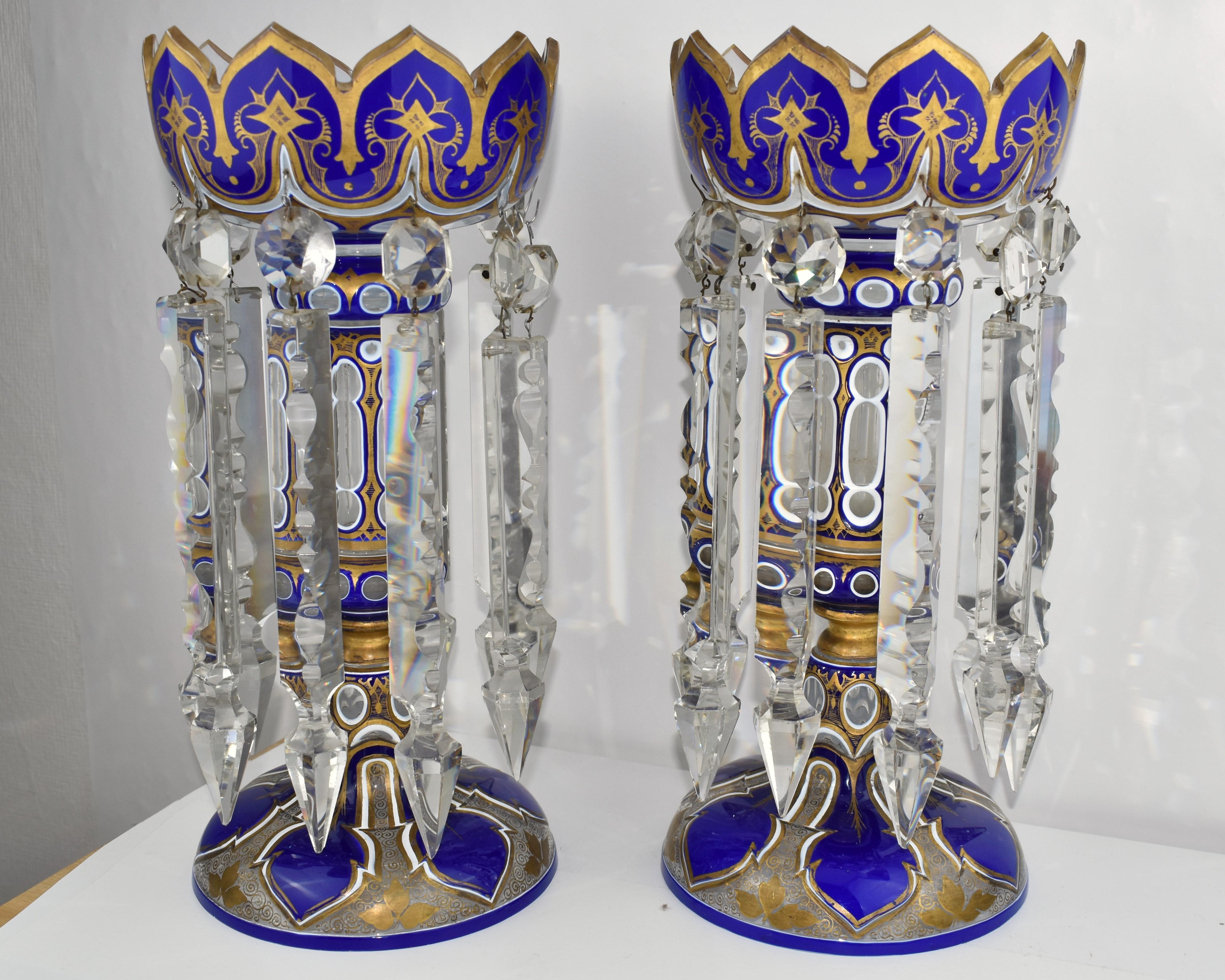 Pair of Blue Glass Lusters in Antique Double Overlay (3 Layers) Cut Glass

Top Quality and Impressive Size 

Glass richly cut in various shapes and decorated all around with gold enamel

Each lustre with multiple hanging hand-carved cut crystal