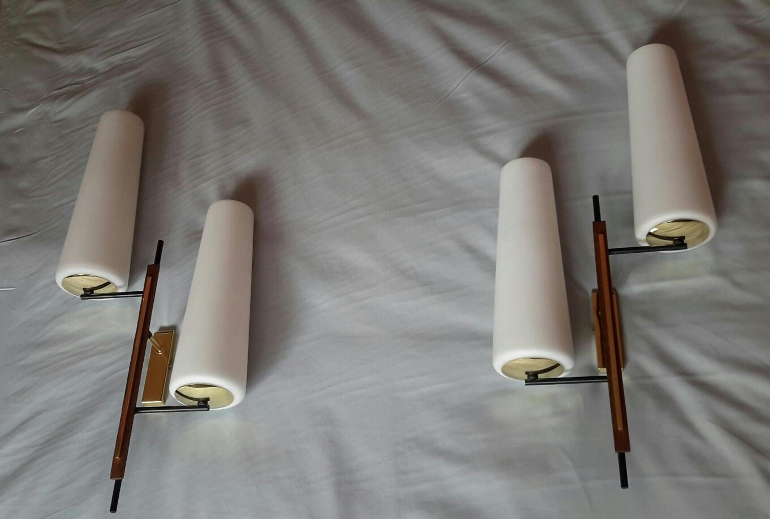 Beautiful and large pair of asymmetrical double sconces from the mid-1950s, French Mid-Century Modern.
In black lacquered metal, wood, brass and white satin opaline glasses.
The sconces are in perfect condition, electric parts have been renewed