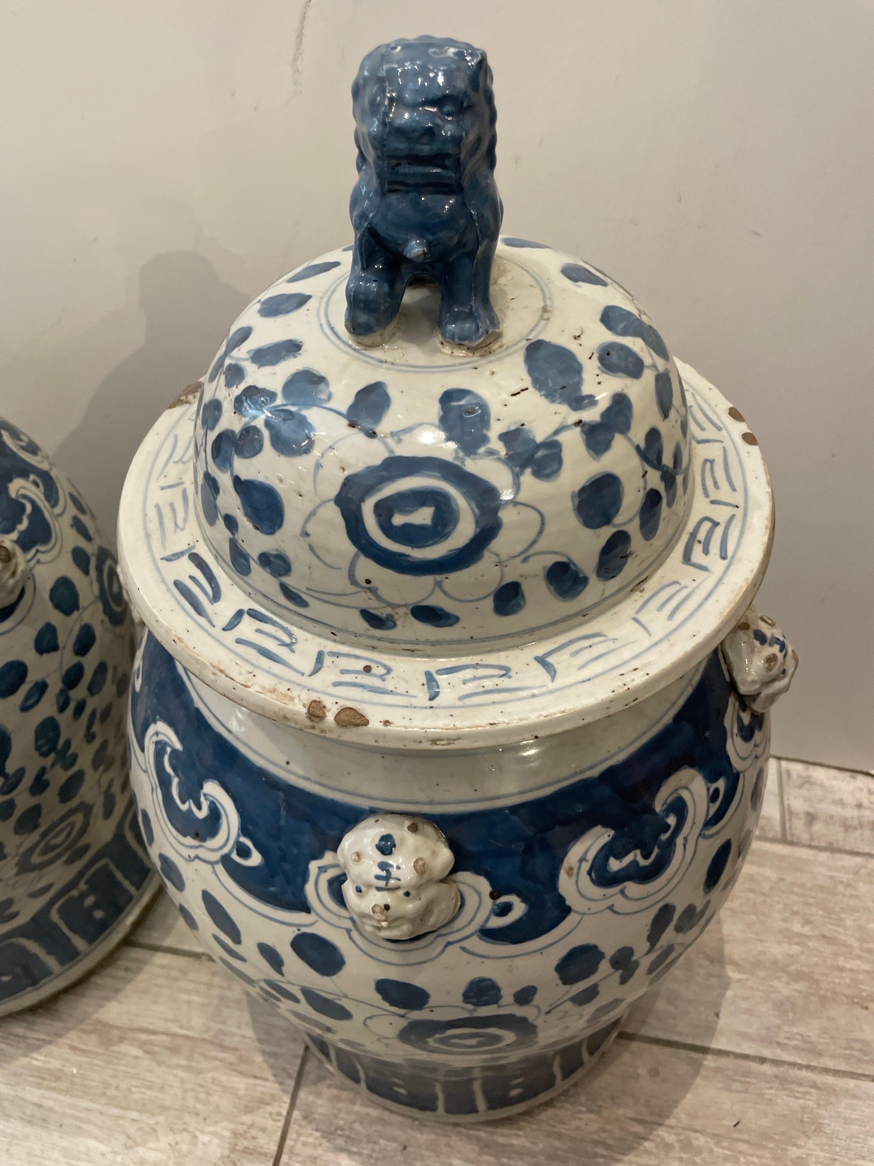 Wunderschönes Vintage-Paar von blau-weißen Ingwerdosen mit Foo-Dog-Aufsatz. Foo Dog Gesichter, die an den Seiten des Glases herausragen. Große Aufmerksamkeit für Details.