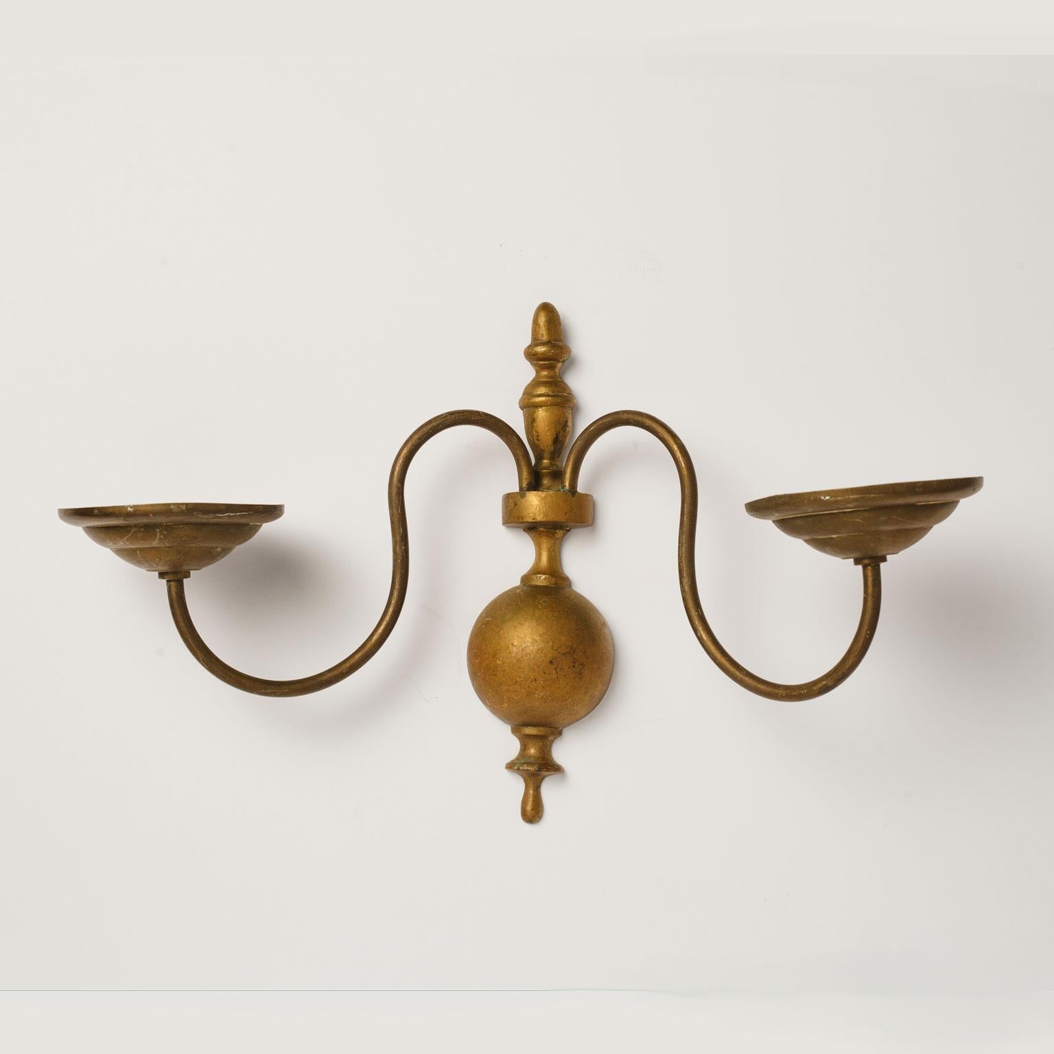 Large pair of brass Georgian style sconces with two arms each. Simple lines and oversized candle cups mark this pair as distinctive and unique. Unwired, but can be wired for electricity for an additional cost. Sold together as a pair for $950.