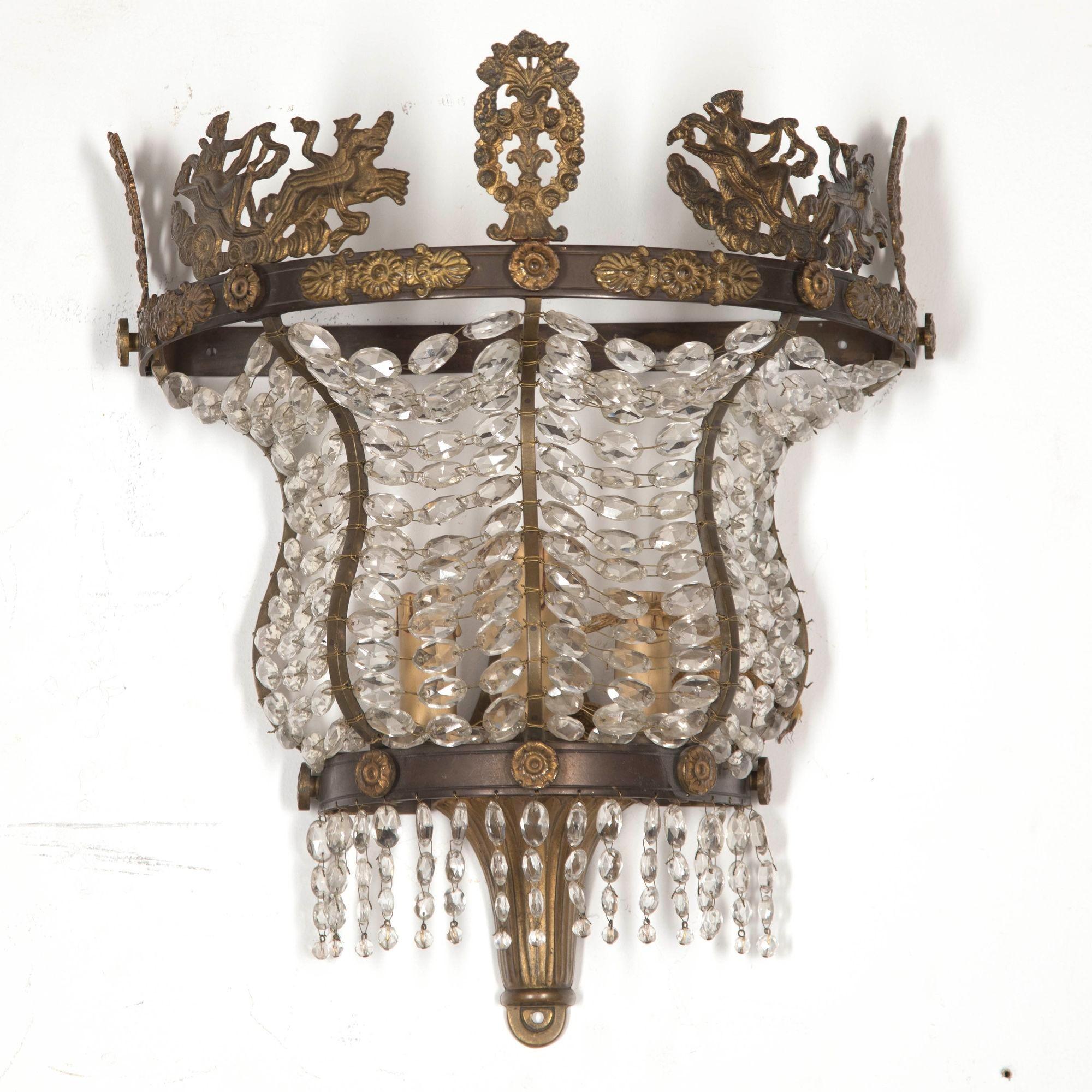 Coppia molto insolita di appliques francesi in stile Impero con cornice in bronzo e montatura in ormolu del XIX secolo. Le montature, ben fuse, raffigurano fanciulle classiche in carrozza centrate da una ghirlanda floreale con grappoli d'uva. Il