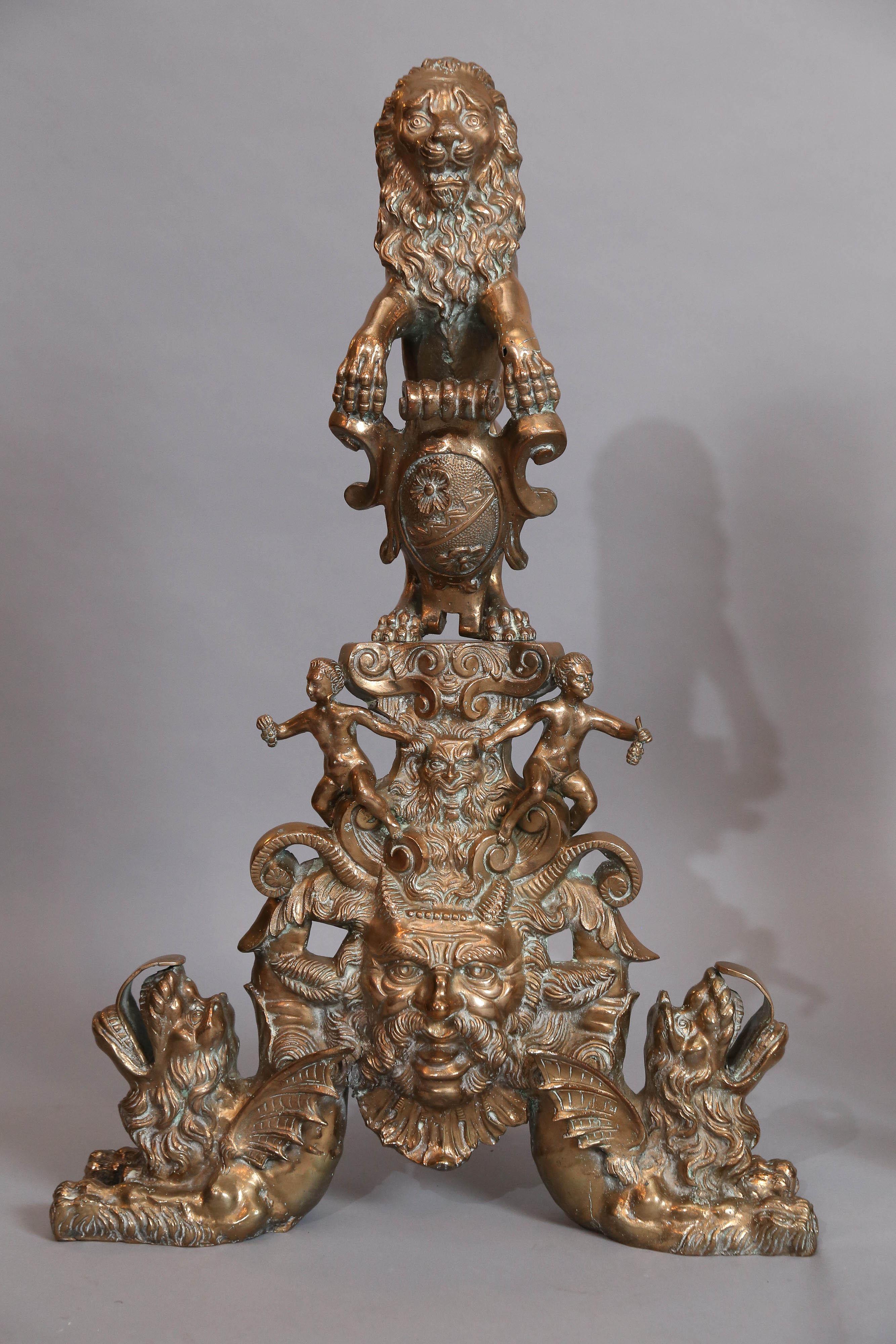 Large pair of bronze and brass Rococo andirons feature a pair of
standing lions each standing on a pair of cherubs with a gargoyle mask in centre, flanked by a pair of winged gargoyles with paw feet.
Quite elaborate.