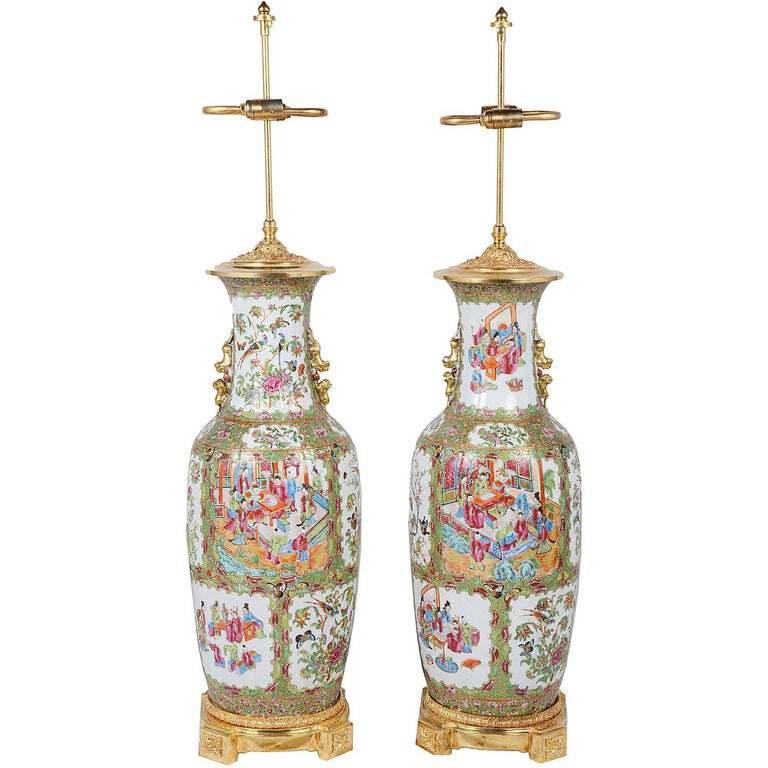 Une paire de grands vases / lampes de Canton chinois du 19e siècle de bonne qualité. Chacune présente un fond vert avec des fleurs, des feuillages, des papillons et des oiseaux entourant des panneaux de diverses scènes de personnes faisant la cour