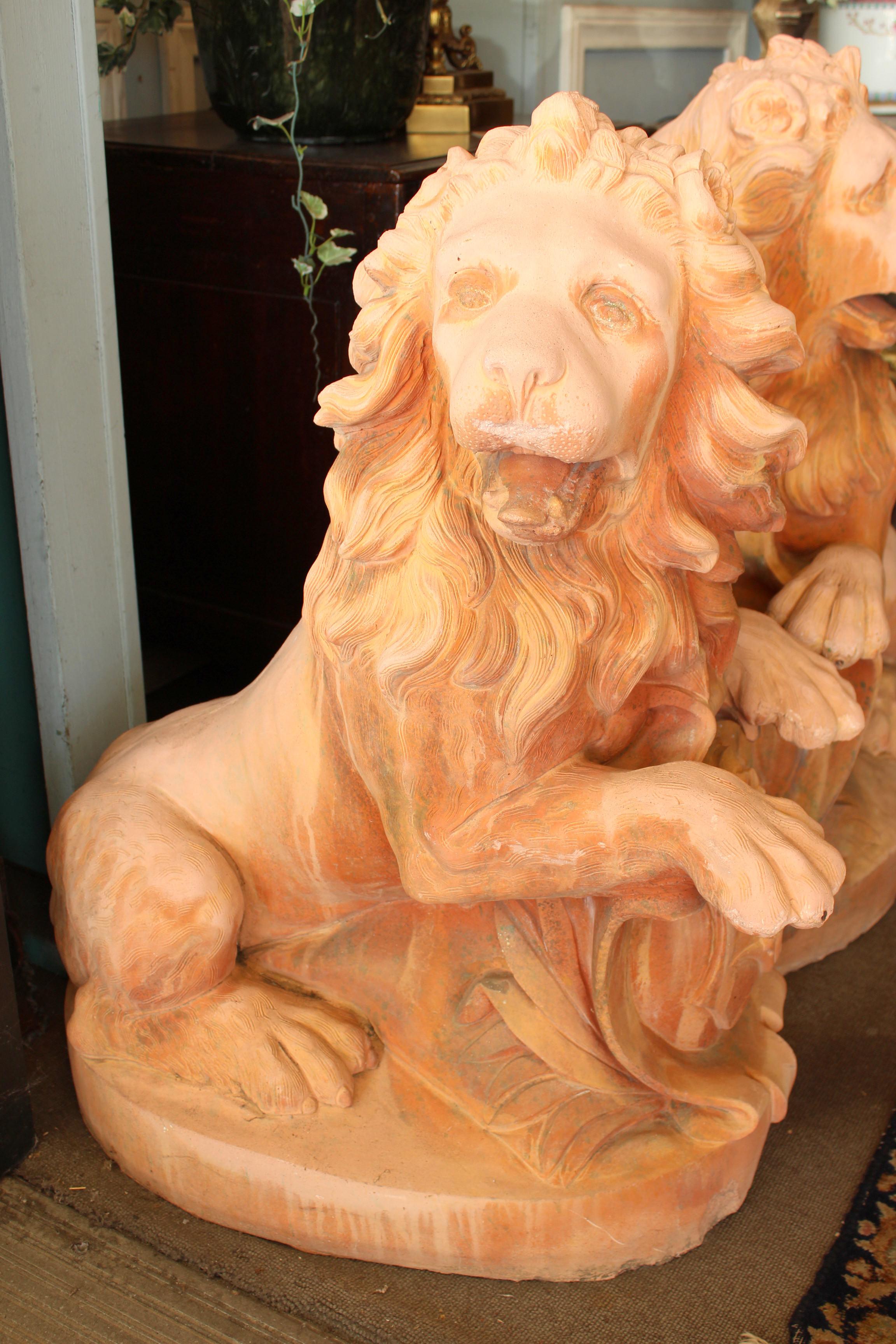 Large pair of cast stone garden lions with terracotta color, approximately 20-40 years old.