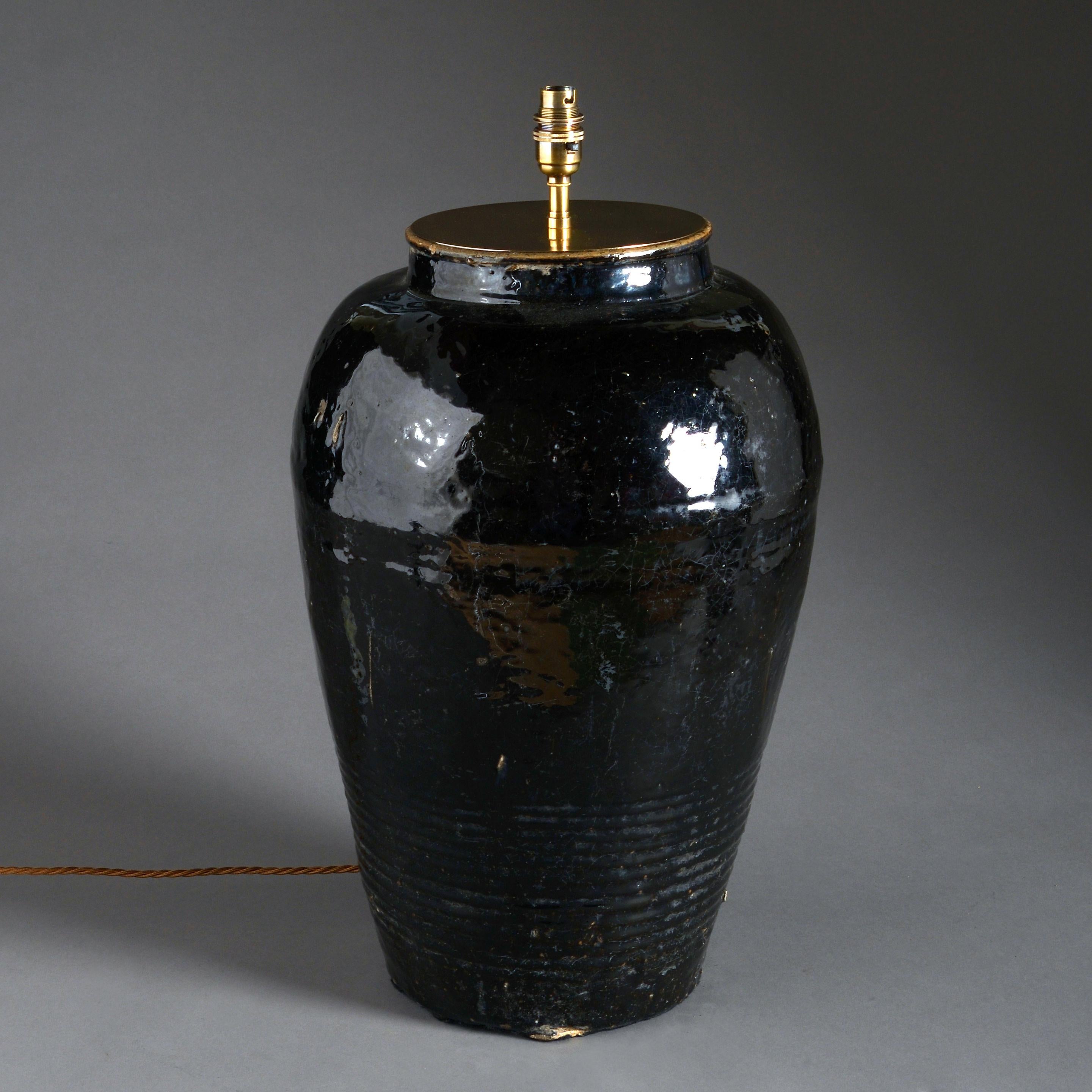 A large pair of black glazed Jars, having turned decoration of rings to the lower body. 

Now mounted as table lamps. Dimensions refer to the height and width of the vases (not including shades).