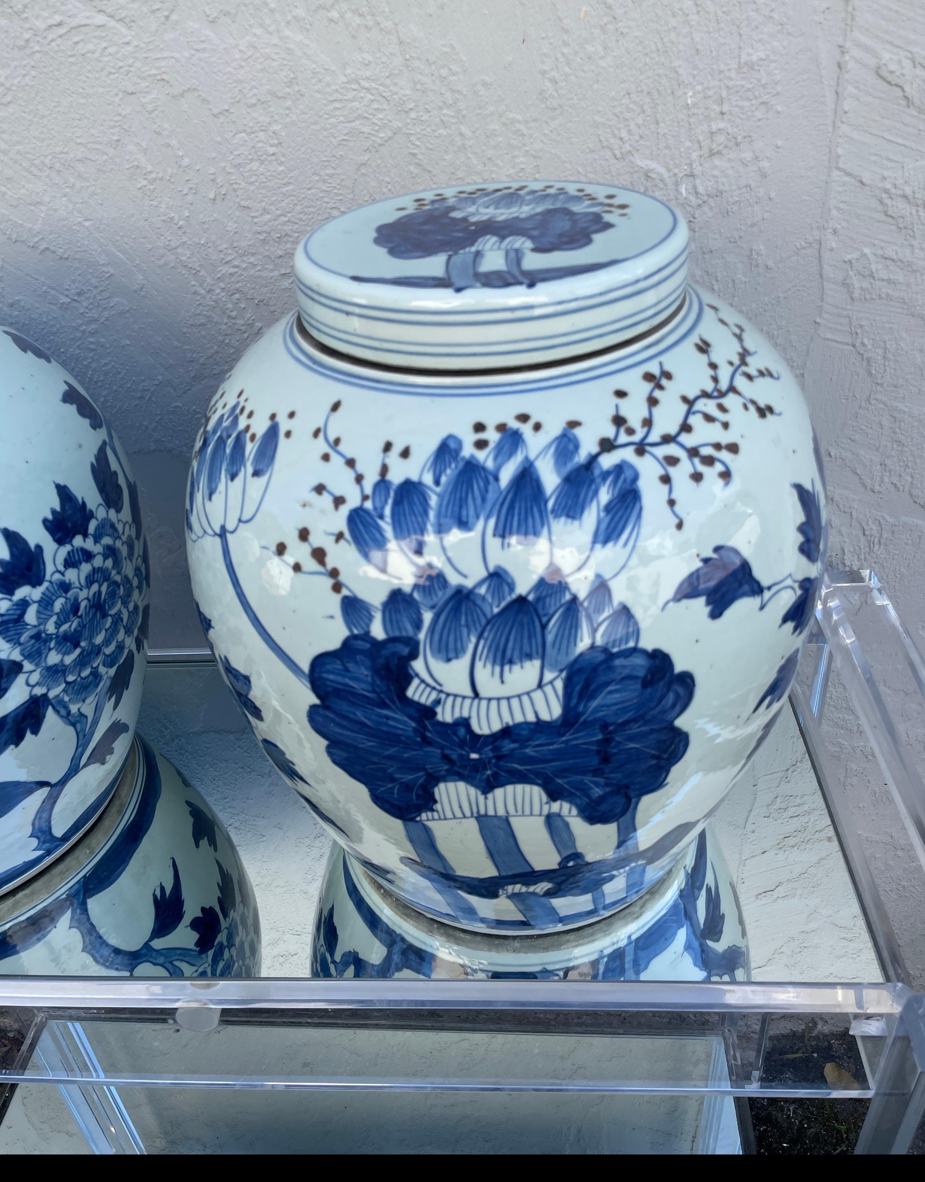 Monumental size Chinese blue and white ginger jars with lids. A very impressive pair. The design appears to be branches of cherry blossoms with other leaf foliage.