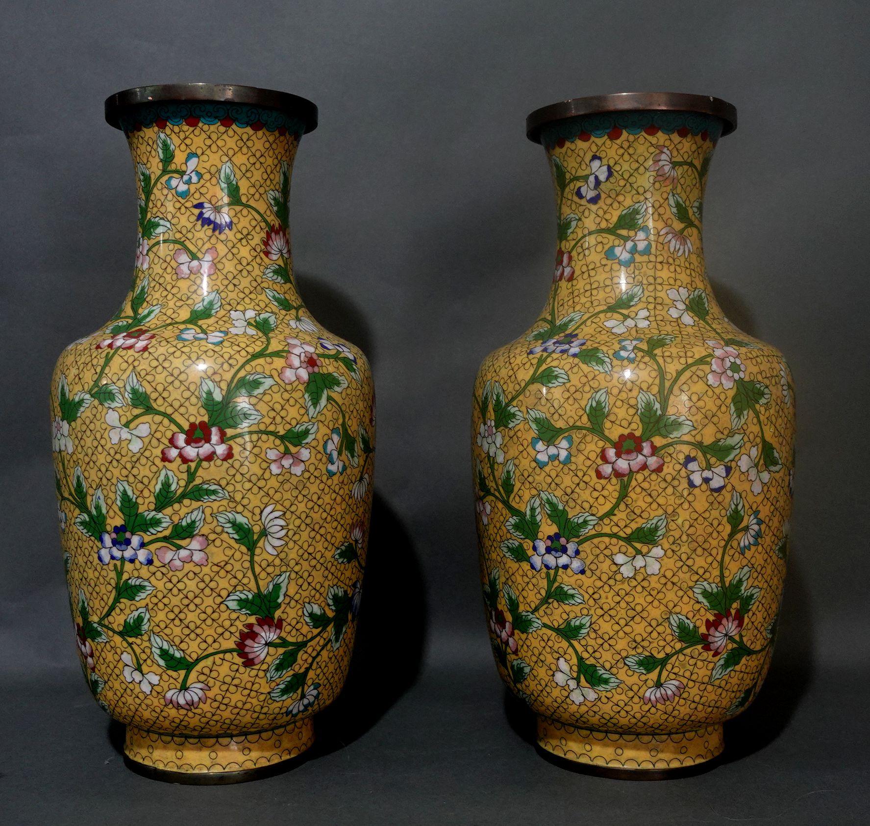 Quality work, large pair of Chinese bronze cloisonné enameled vases depicting the scene of florals on a yellow ground with vivid colors of green, red, blue, and white.
The items are in good condition, with a small enamel lost in a very small area,