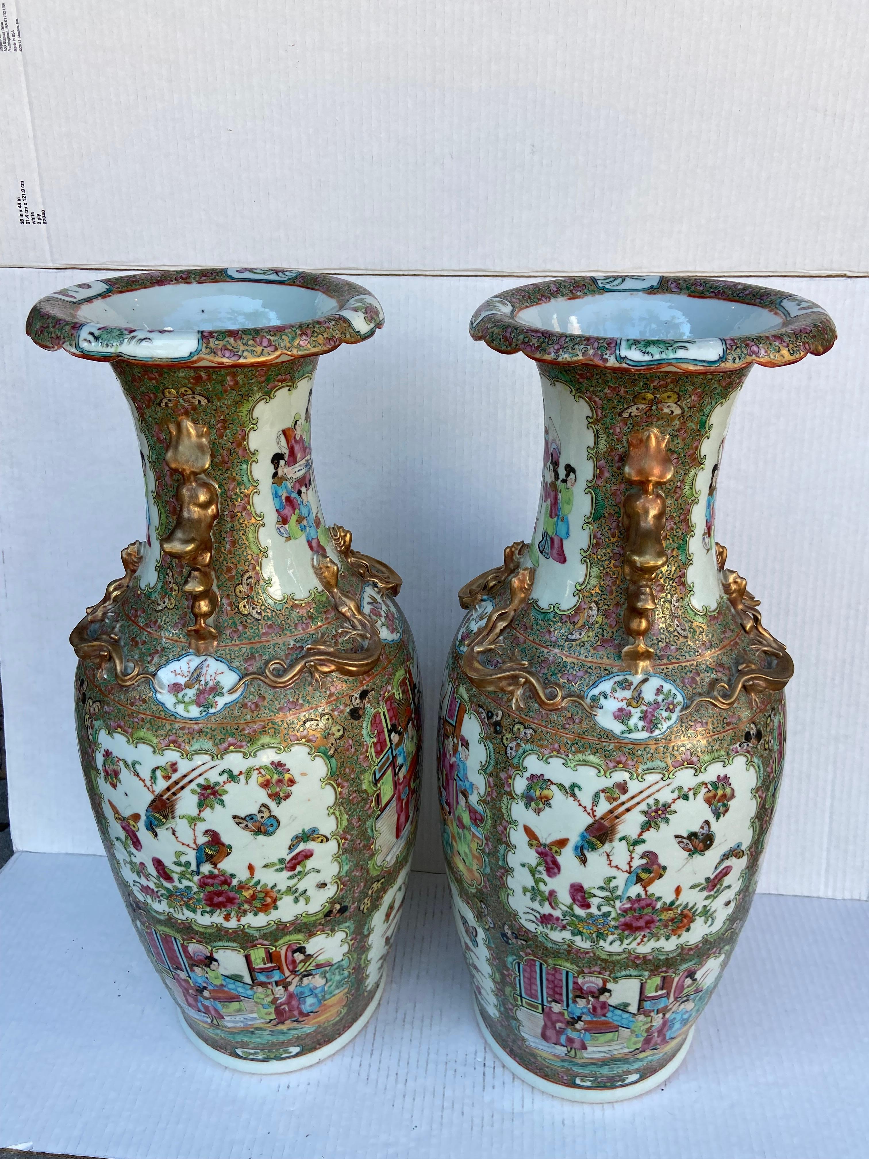 Large pair of Chinese Rose Medallion vases. Gilt lion handles with dragons surround. Rose Medallion typically has alternating panels of people and varying combinations of flowers, birds, insects, fruits, and fish...Often, the central medallion in