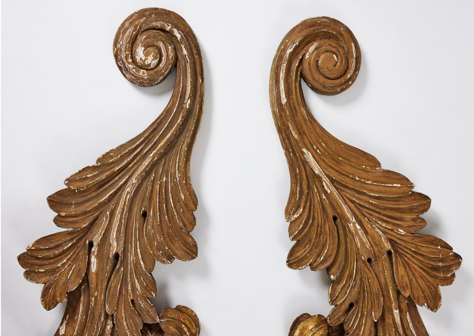Paire de grandes sculptures décoratives et impressionnantes en bois baroque suédois vers le 19e siècle, représentant des acanthes et des volutes tourbillonnantes.
Peint en ocre foncé avec des traces de dorure sous-jacente apparaissant sous la