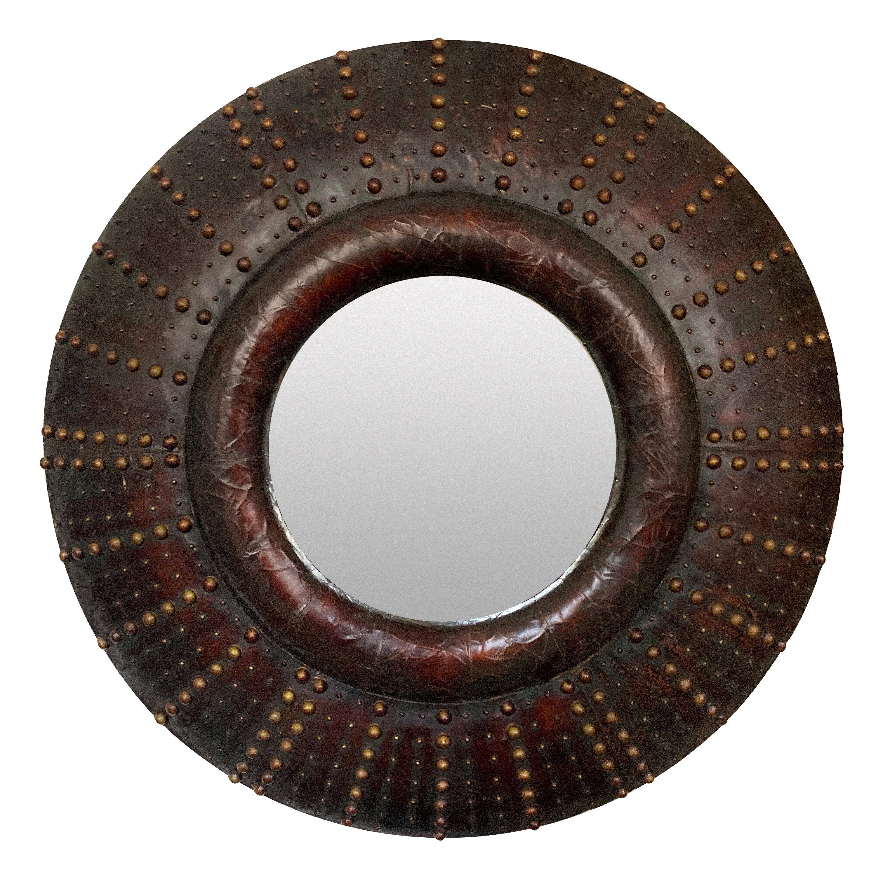 A large pair of English, circular leather-clad cushion mirrors, with an antique gold beaded decoration.