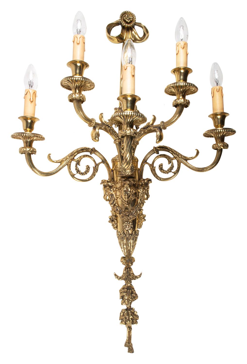 A large pair of classical 19th century French gilded ormolu wall lights / sconces, each with five branches, scrolling foliate, mask and ribbon decoration.