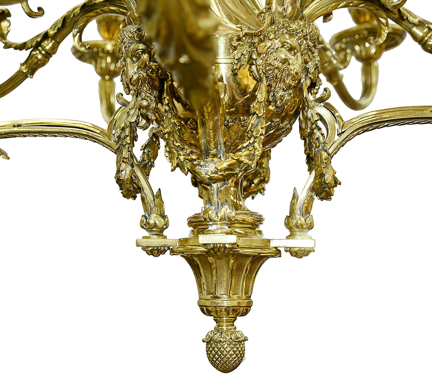 A very impressive large pair of 19th century classical ormolu 20 branch chandeliers, each having swag, foliate and scrolling decoration. Scrolling out swept arms with sconces, Rams heads and acorn finals to the bases.