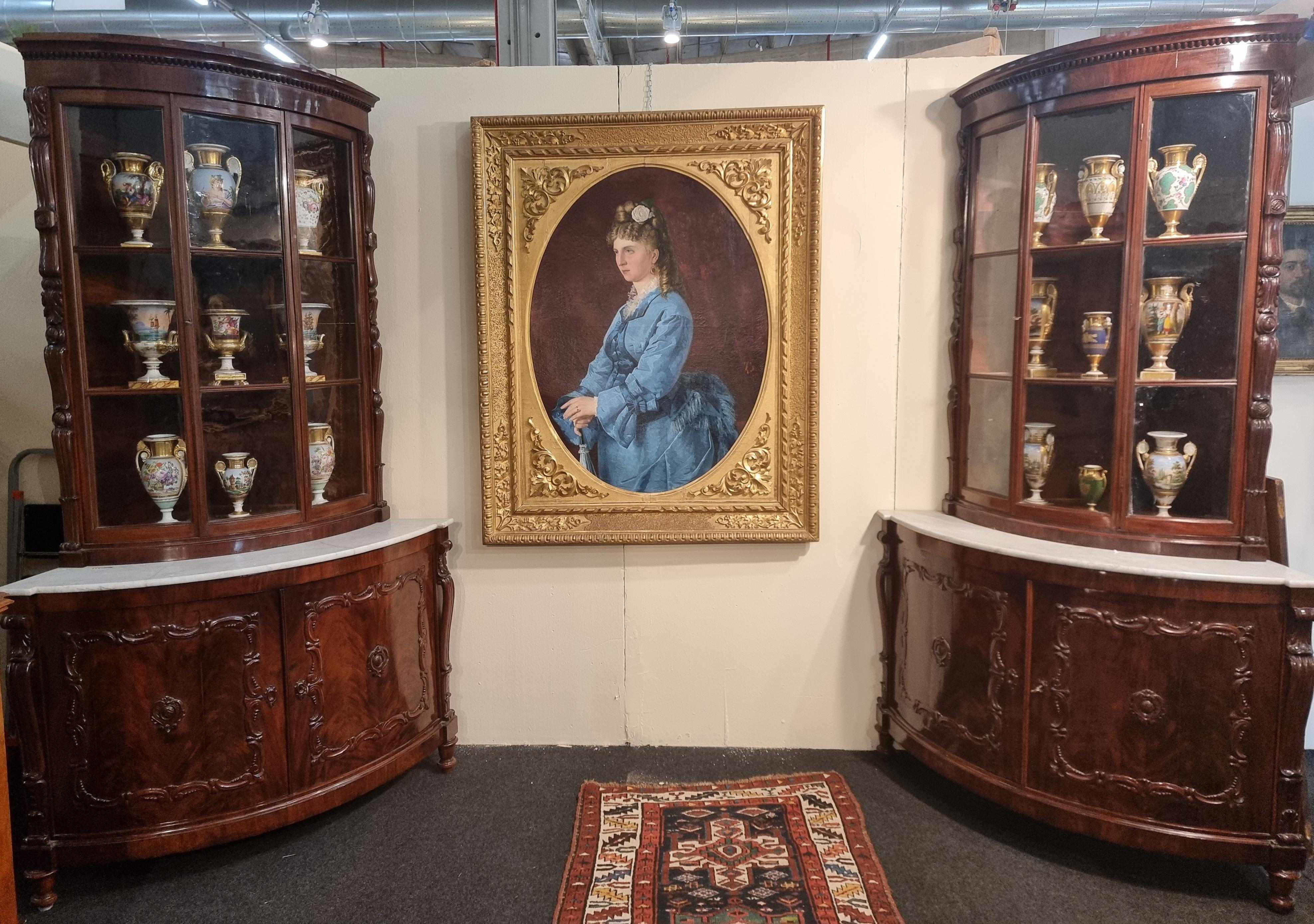 Splendid pair of Livorno corner cupboards from the second half of the 19th century in mahogany wood with original patina. the two corner units have tops in white Carrara marble. On the sides they have carved friezes, the lower part has two rounded