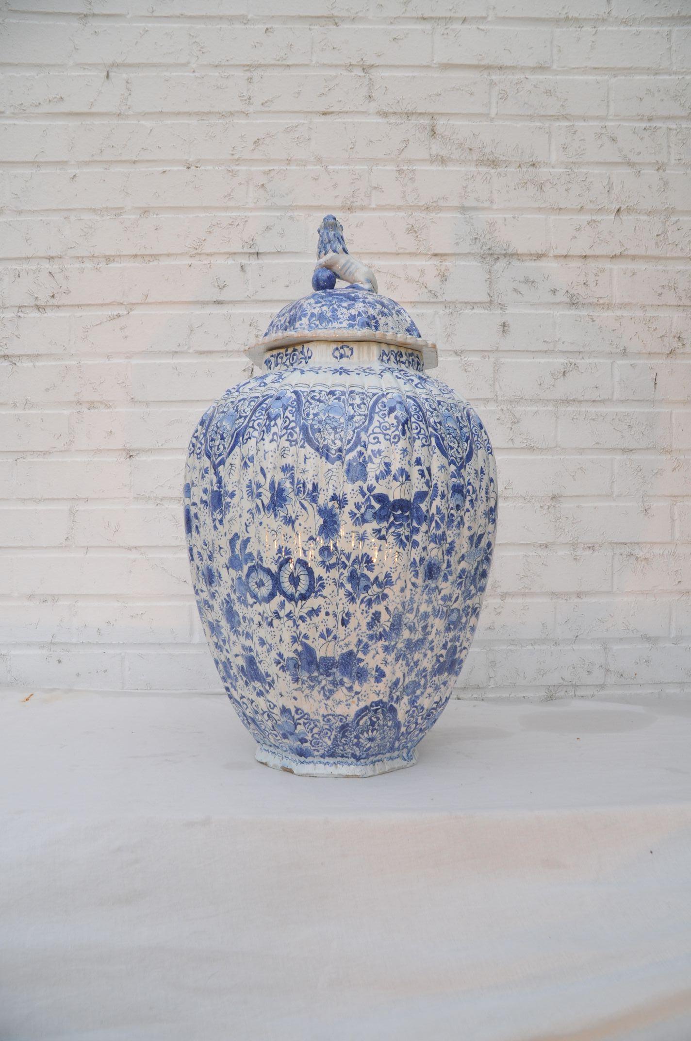 Large pair of Dutch Delft Jars circa 1800 signed in underglaze blue with an ax.
The octagonal ribbed baluster body strewn all over with myriads of flowers, 
peacocks and geometric lines to the upright neck.
The domed cover decorated en suite