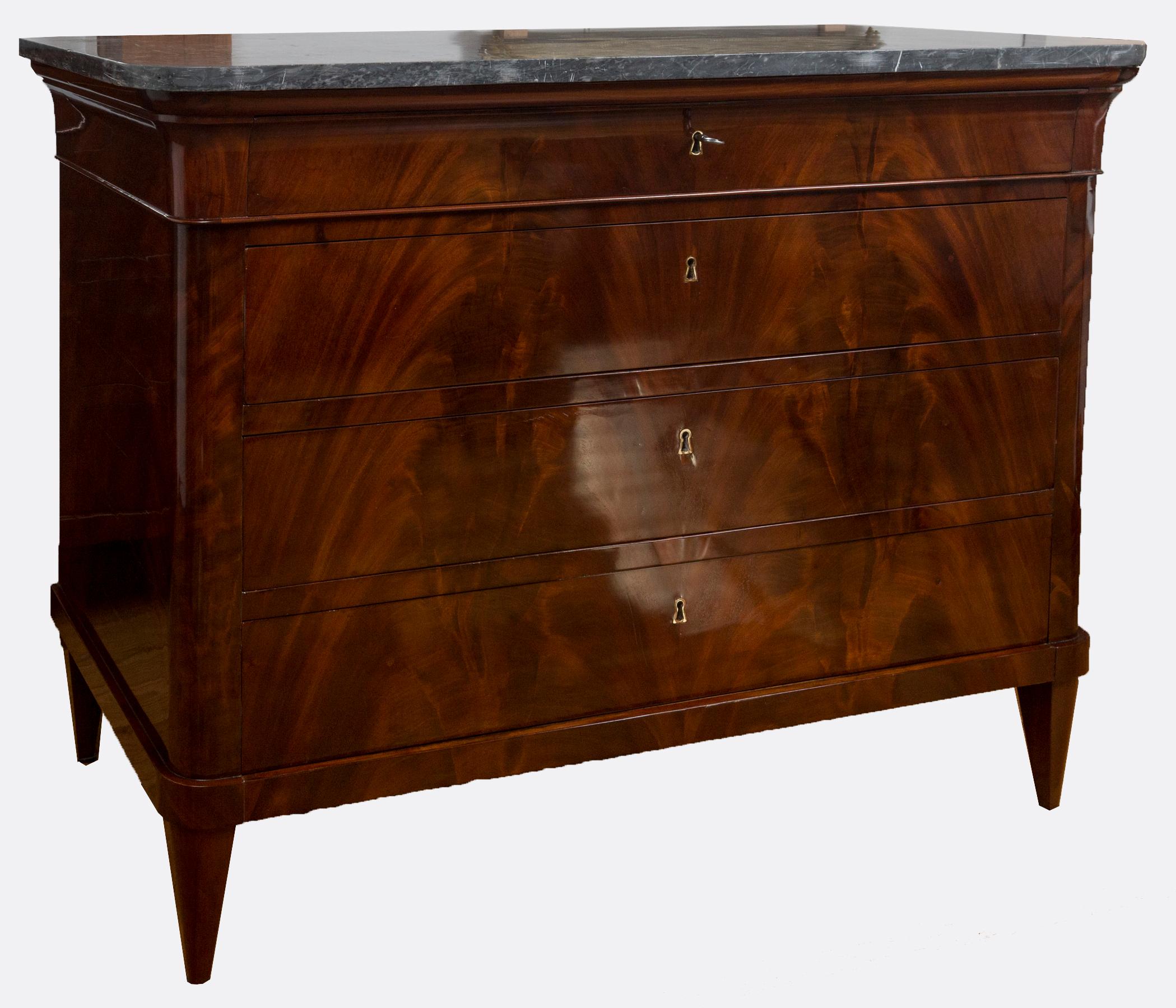A fine pair of sleek early Empire chests shown with its orginal thickly handcut light grey marble tops above four long drawers adorned simply with a beautiful bookmatched Cuban mahogany flame veneer and finishing on tapered straight legs. Drawers