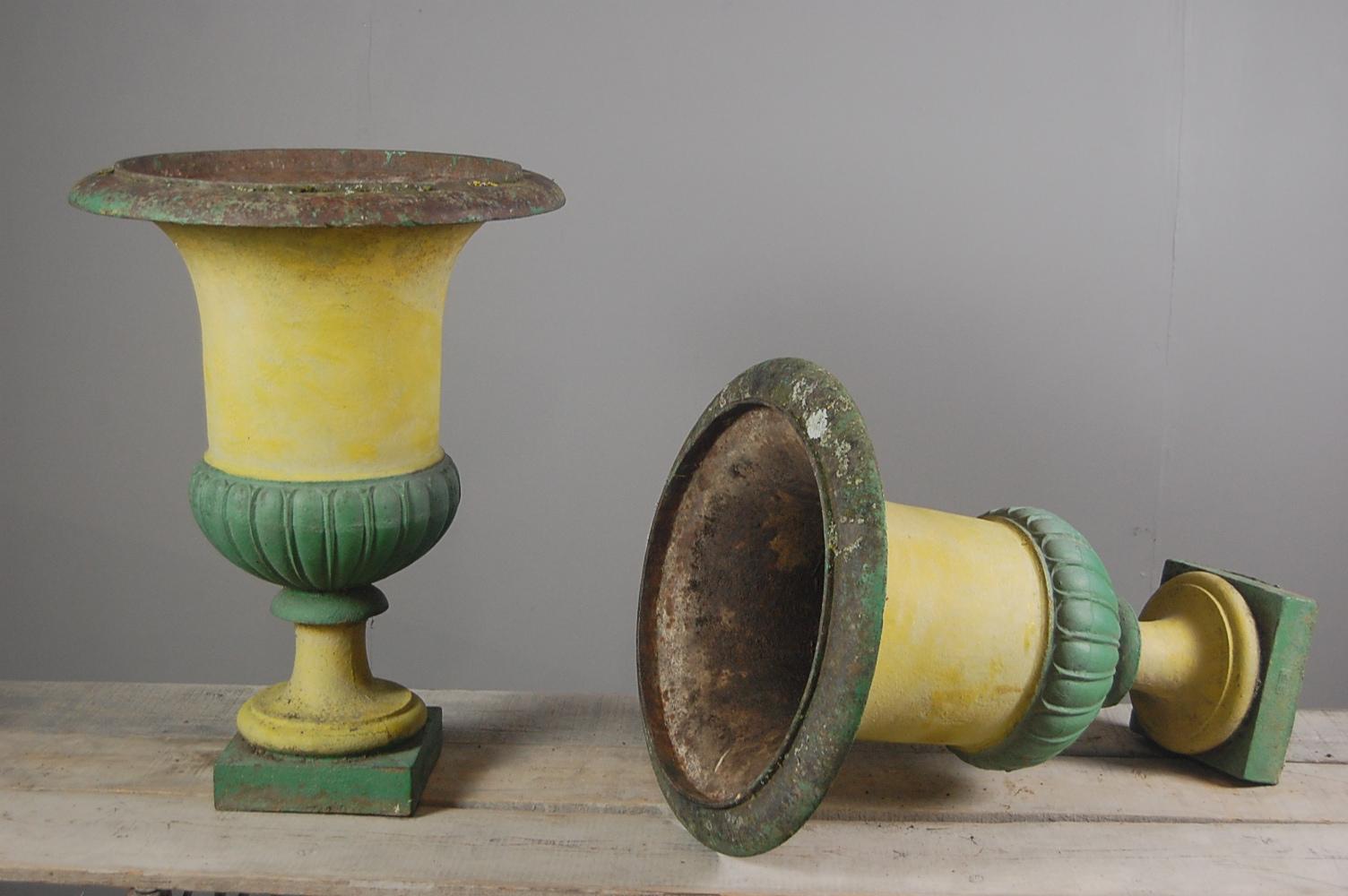 Pair of large form Campana urns in cast iron. Painted green and yellow, well weathered. These are from Provence, France, which may well explain the color and remarkable condition. France, early 20th century.