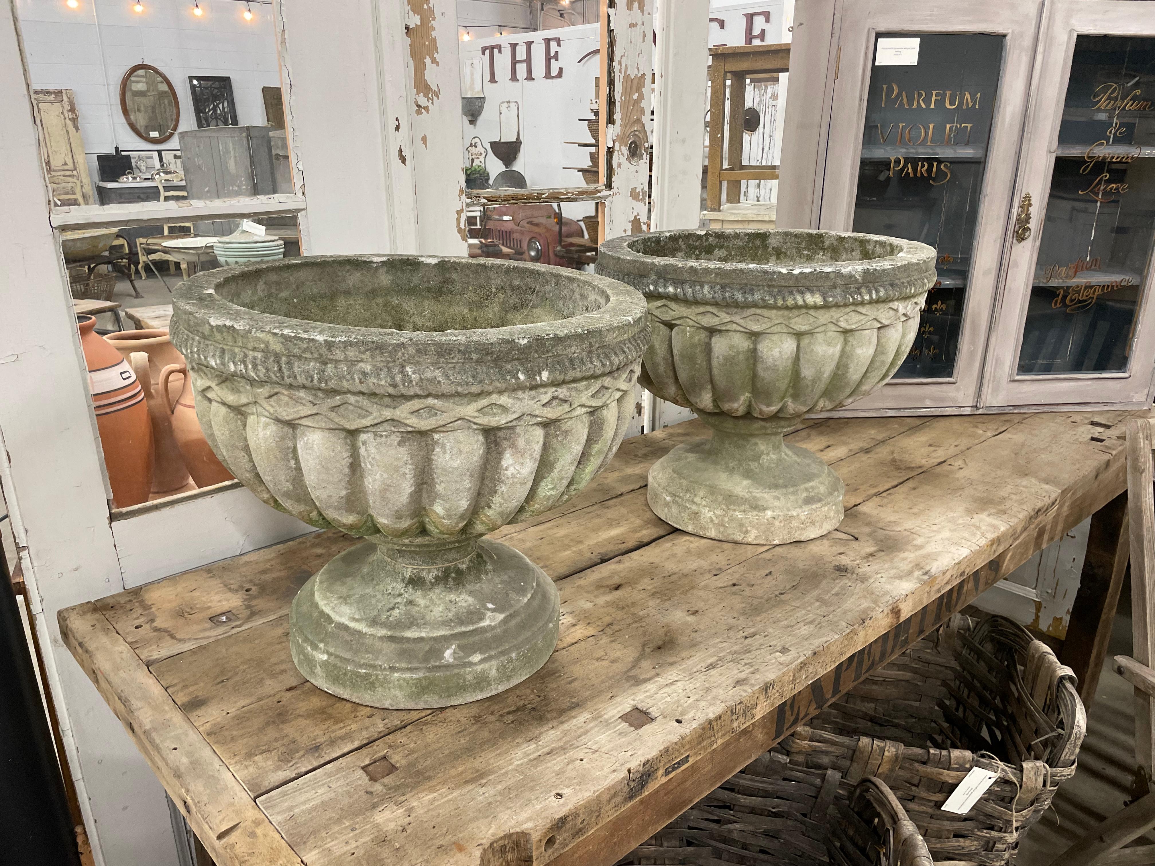 Pair of quintessential English vintage composite stone lobed urns. Wonderful large scale bowls on socle bases with lozenge pattern above the lobes and a rope pattern around the rims..



