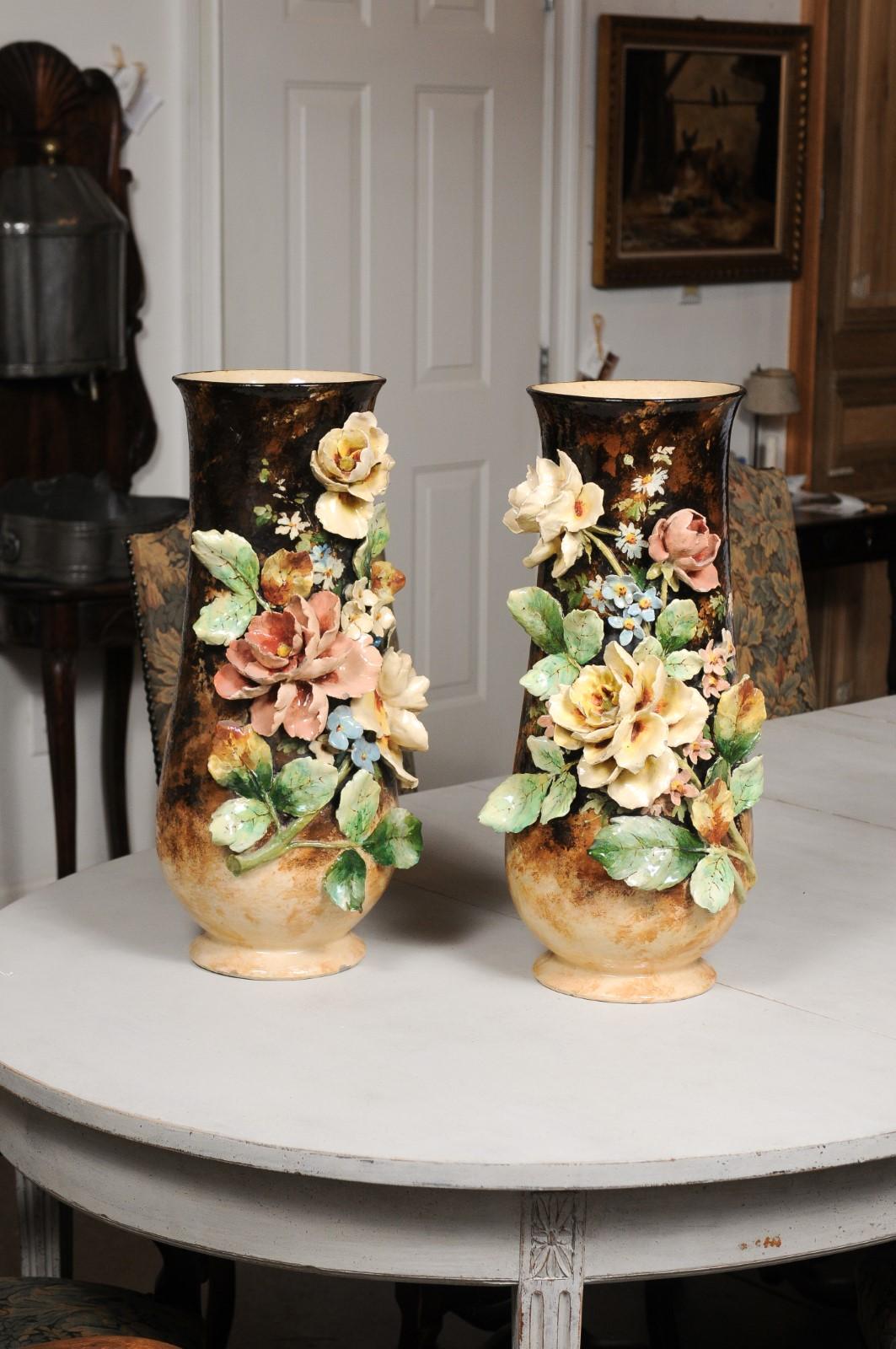 A large pair of French barbotine vases from the 19th century, with high relief floral décor. Created in France during the 19th century, each of this pair of barbotine vases features a high relief floral décor with amazing colors and great detail,
