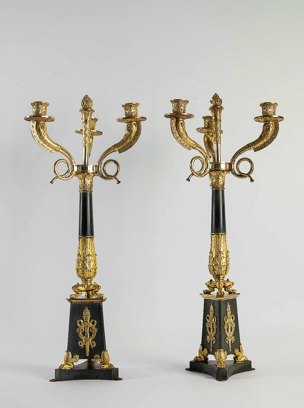 A magnificent large pair of three-light gilt bronze and patinated-bronze Restauration period candelabra, manufactured in the early 19th century circa 1815-1830. This pair of candelabra is set on a patinated-bronze base with ormolu mounts held up by