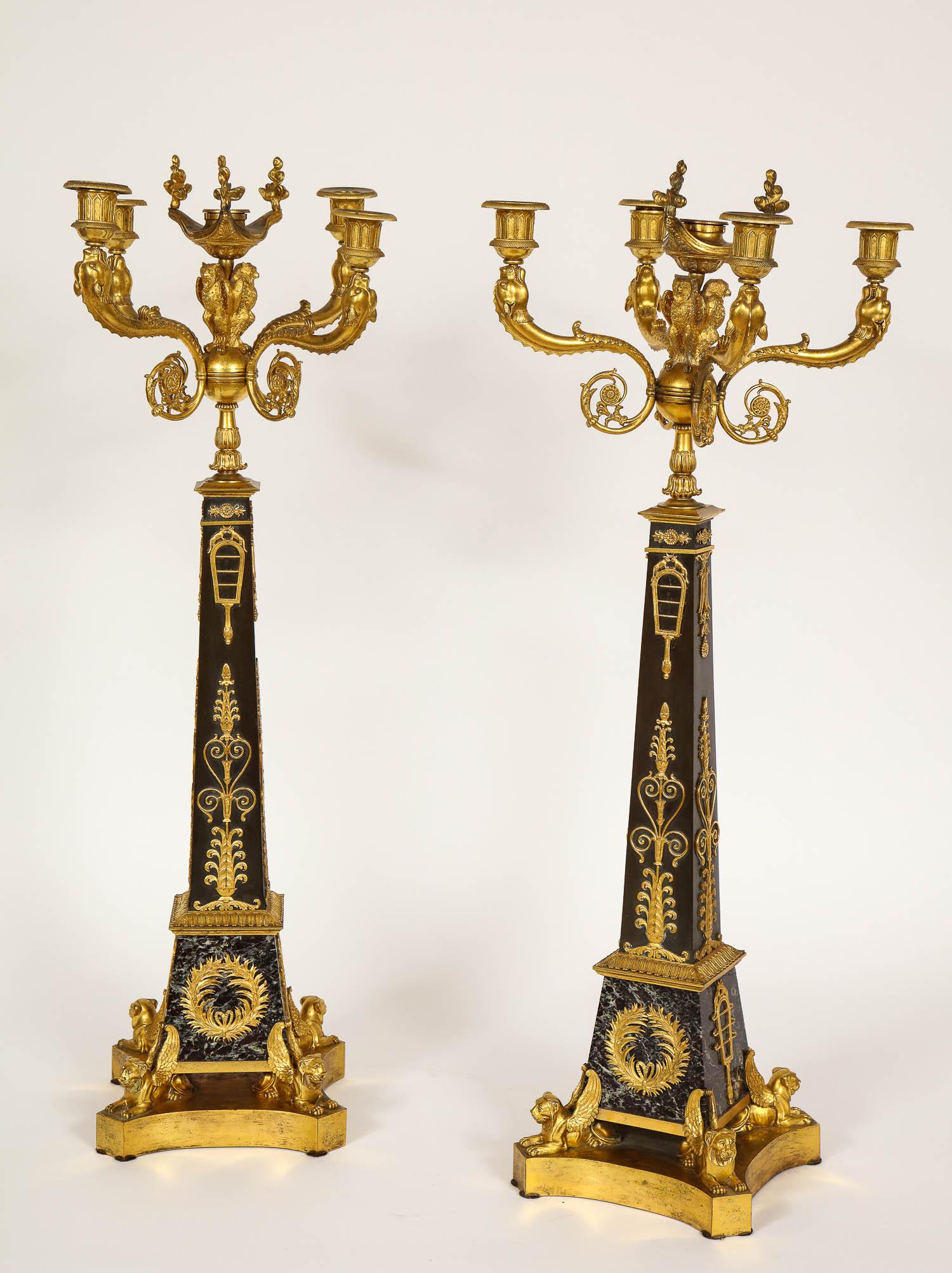 Ein prächtiges, großes Paar fünfflammiger Kandelaber aus Doré-Bronze und patinierter Bronze aus der Empire-Zeit, die Claude Galle zugeschrieben werden und in den frühen 1800er Jahren hergestellt wurden. Dieses Kandelaberpaar steht auf einem Sockel