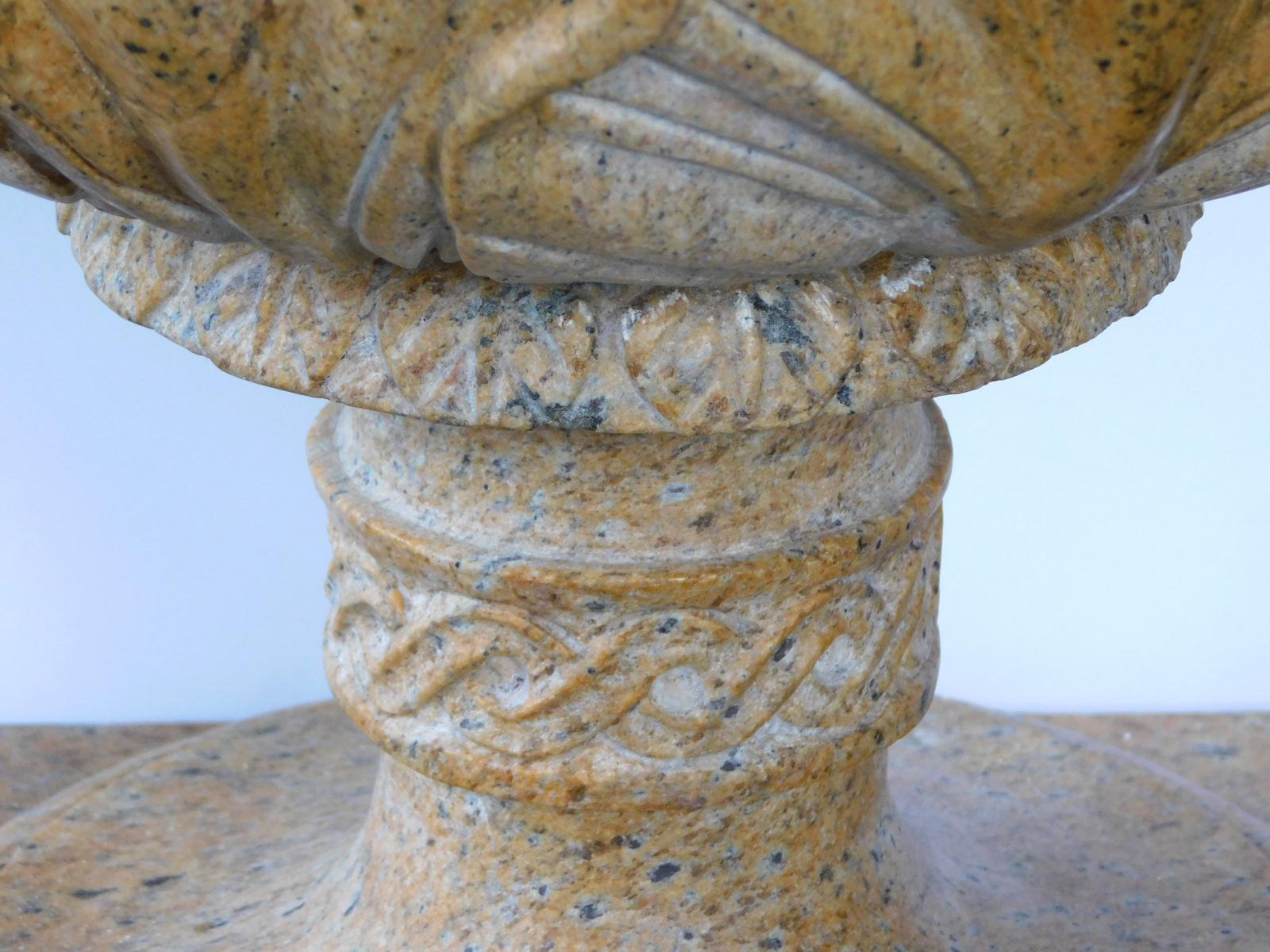 Each well-carved finial in an ochre-colored well-mottled granite, resting on separate bases.