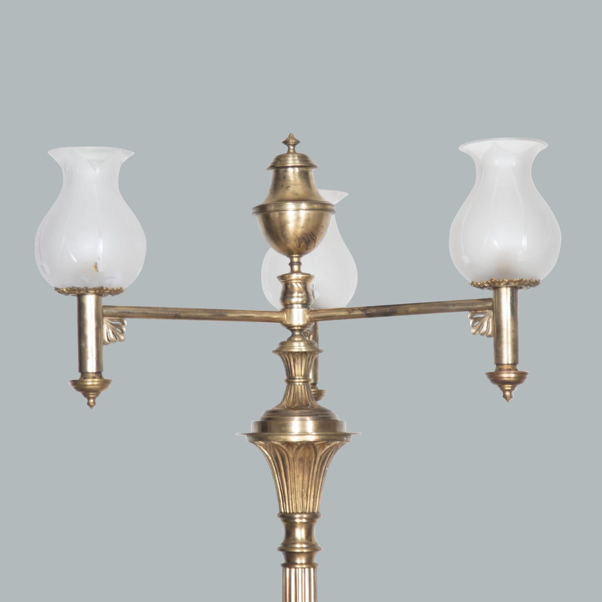 An imposing pair of neo-classical gilt bronze 3 light candelabra/standard lamps, each branch with part frosted tulip shaped glass shades, leading onto fluted columns capped with moulded finials and styff leaves to the base, terminating in powerful