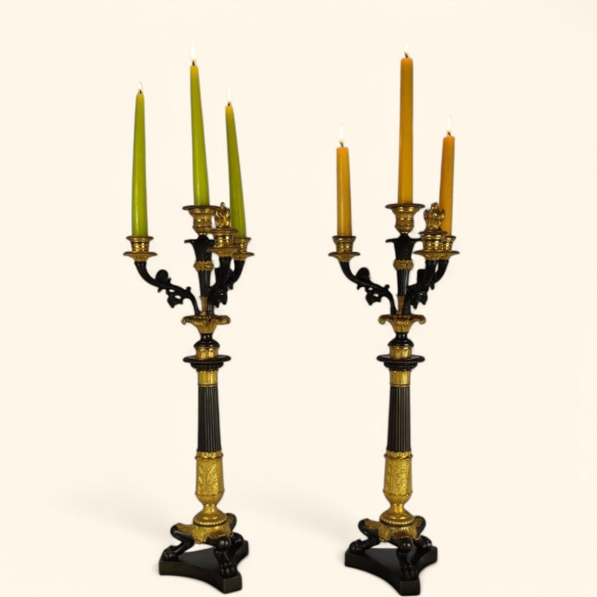 Grande coppia di candelabri del periodo della Restaurazione francese del 1820 circa a quattro luci in bronzo con doppia patina, dorata e brunita.

Sovrastati da un candeliere centrale, tre bracci di luce, decorati con fogliame, volute e foglie