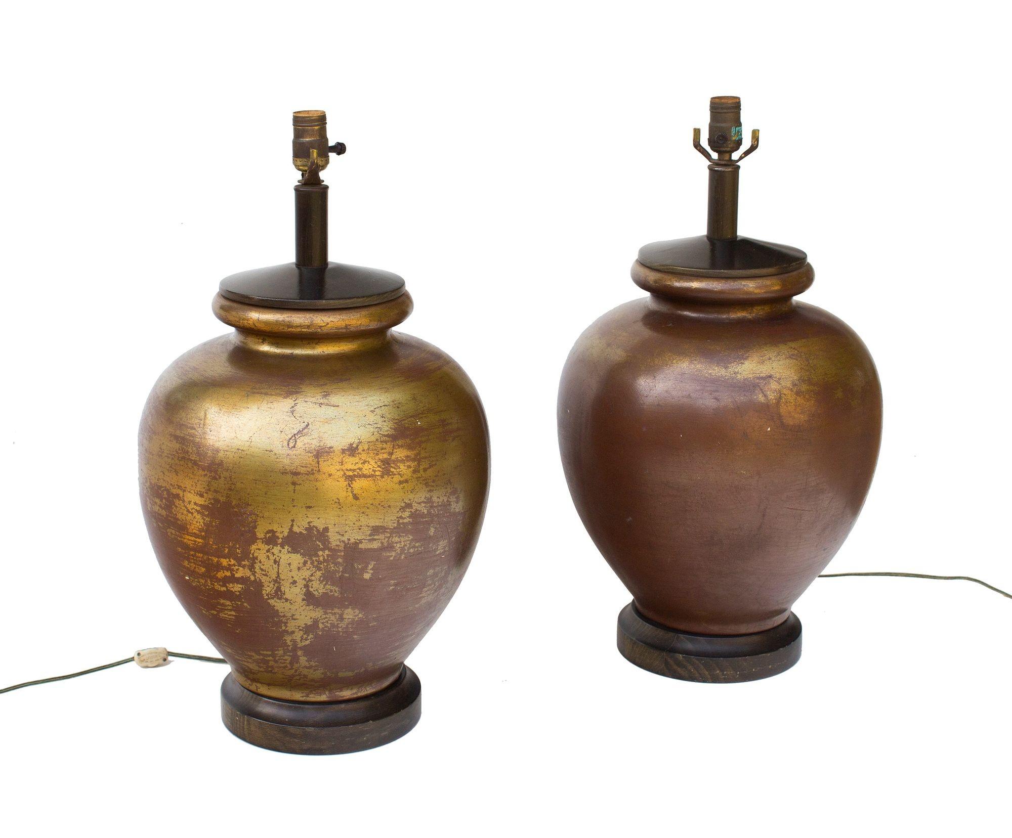 USA, 1960s
Large pair of golden ceramic table lamps. These have wenge-finished wooden fittings at both the top and bottom of the ceramic form. The lamp bodies have a varied glaze that goes from a deep, rich bronze to a golden finish- I believe it