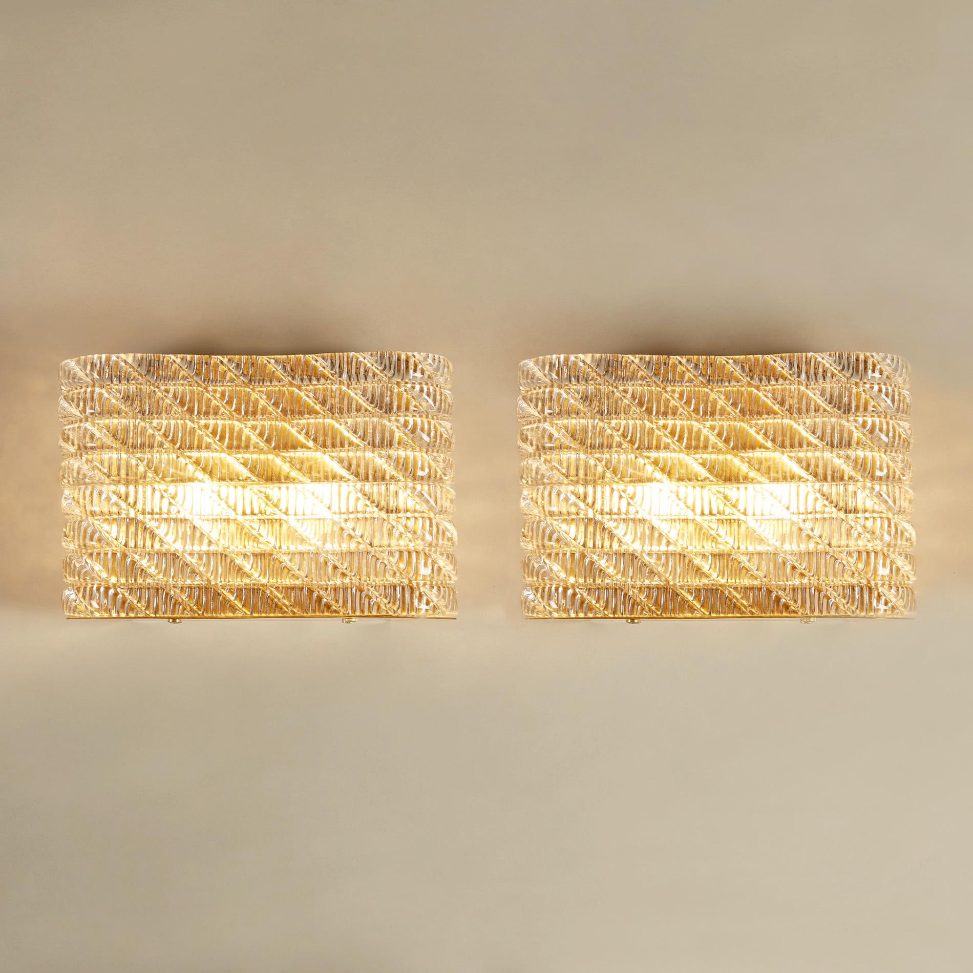 Glamorous large pair of wall lights with curved corners. The criss-crossed Murano glass pattern sits on a curved brass back plate and base, creating a flattering diffused light.


