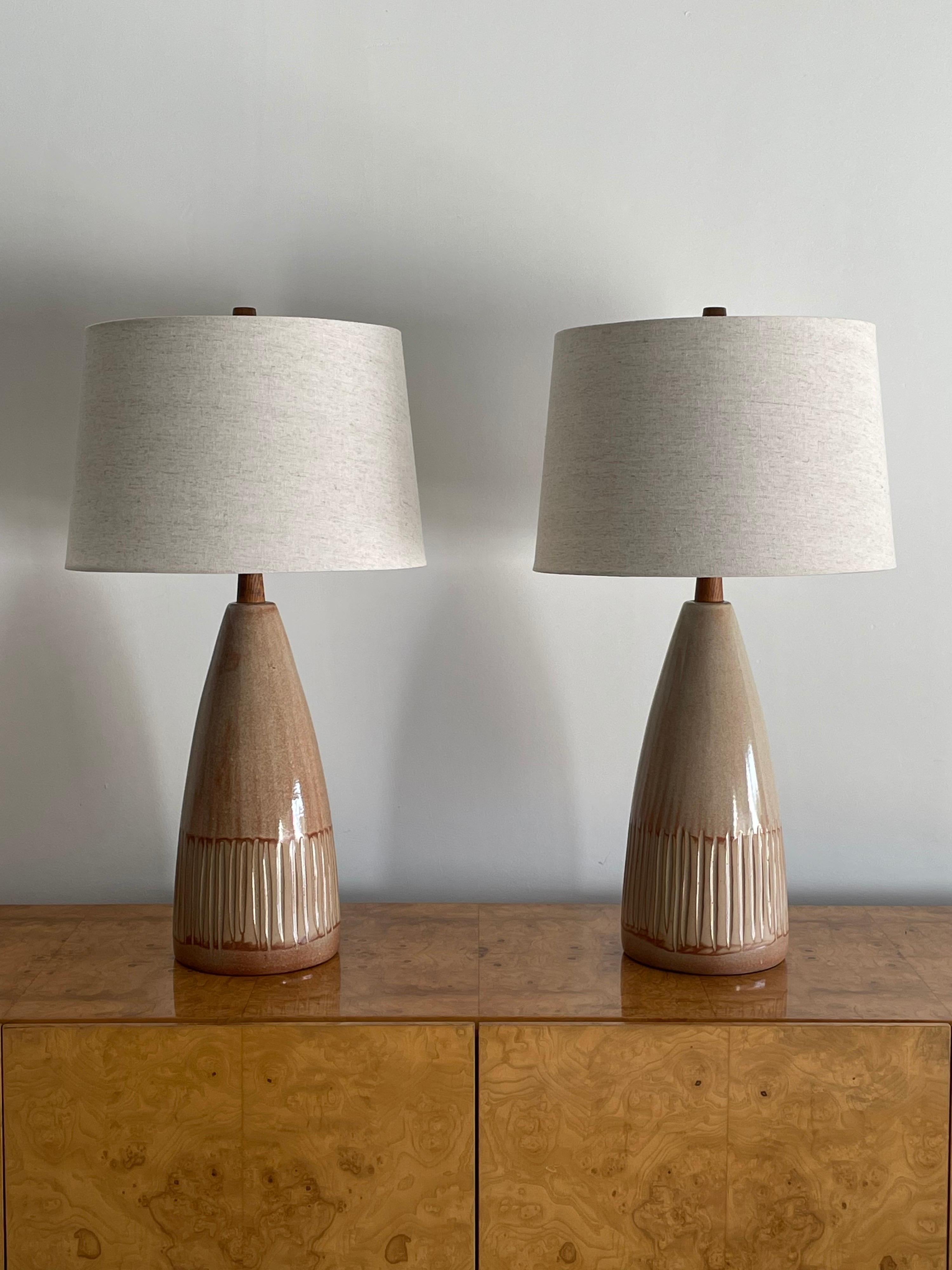 A large pair of table lamps designed by famed ceramicist duo Jane and Gordon Martz for Marshall Studios. Features a rose/ blush color over a sand base. 

Measures: Overall 
28” tall
15” wide

Ceramic 
15.25” tall
7” wide.