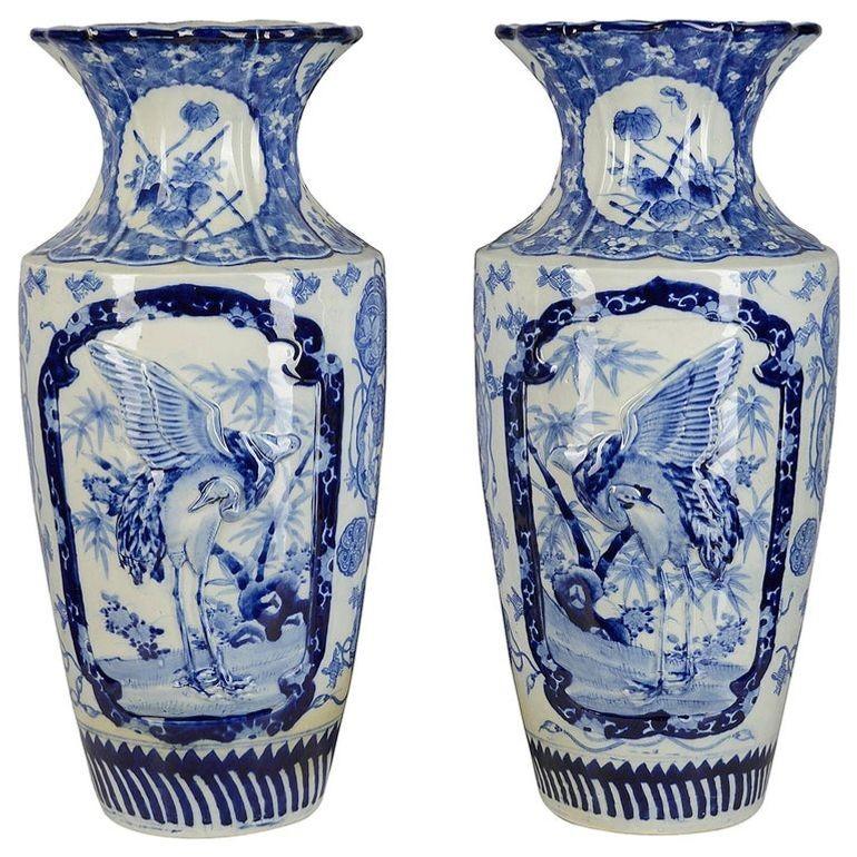 Très impressionnante paire de vases japonais bleu et blanc de la fin du XIXe siècle, chacun avec un décor de fleurs de prunus sur le col, le corps effilé avec des panneaux peints incrustés de grues exotiques et de motifs classiques.
Ces vases
