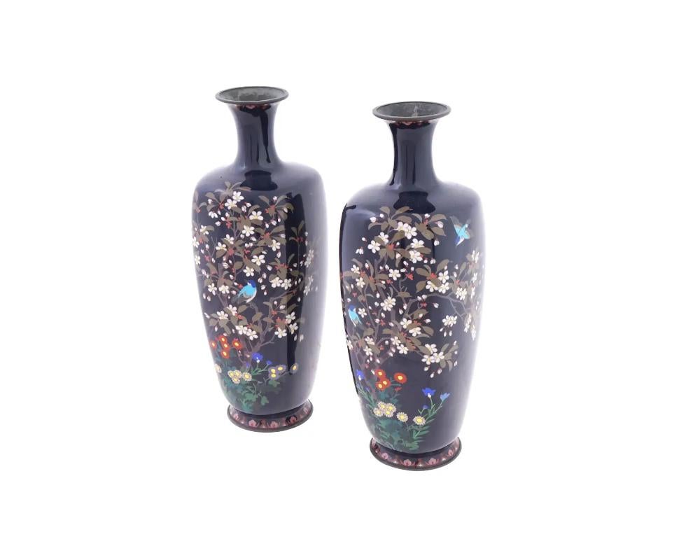 A set of two vases with magnificent flowers and birds decoration, classic form for Japanese works of the Meiji era. The baluster form vases are enameled with polychrome images of blossoming flowers and plants made in the Cloisonne technique on a
