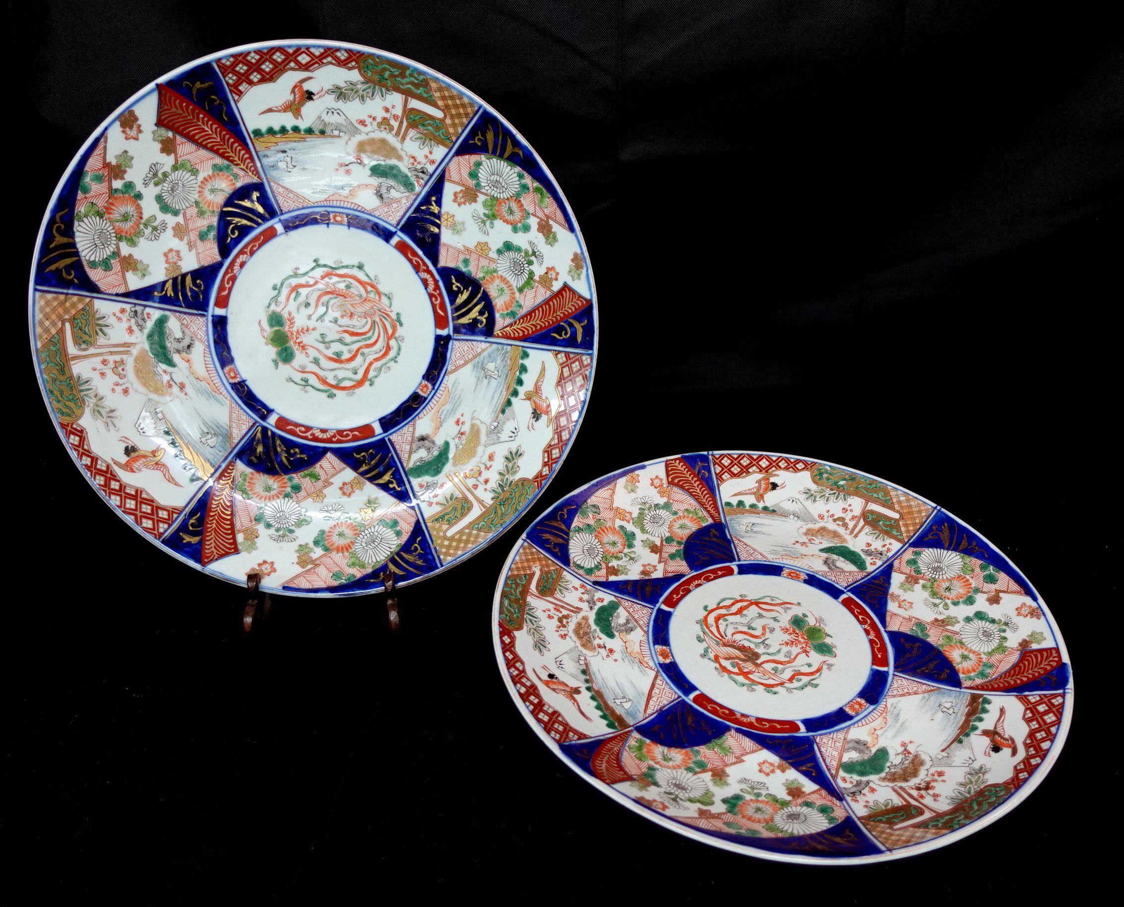 A Pair of large Japanese Imari Chargers from the Maji period of the 19th Century with phoenix and garden scenes designed in 6 different patterns surrounding the entire charger and a painting of a phoenix dominating the center part forming the