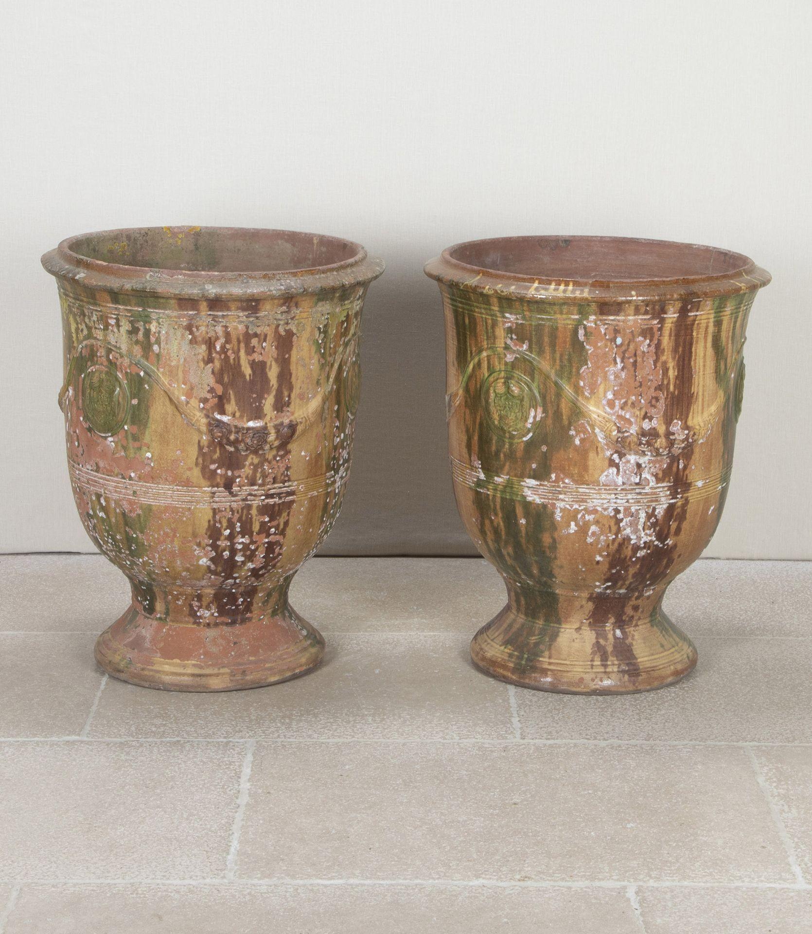 Large pair of late 19th Century French glazed terracotta Vase d'Anduze planters. 
From the Boisset family, formally the Gautier workshop. Of campagna form featuring cabochons and swags. Inscribed 'Boisset, Anduze'. Displaying a beautifully worn