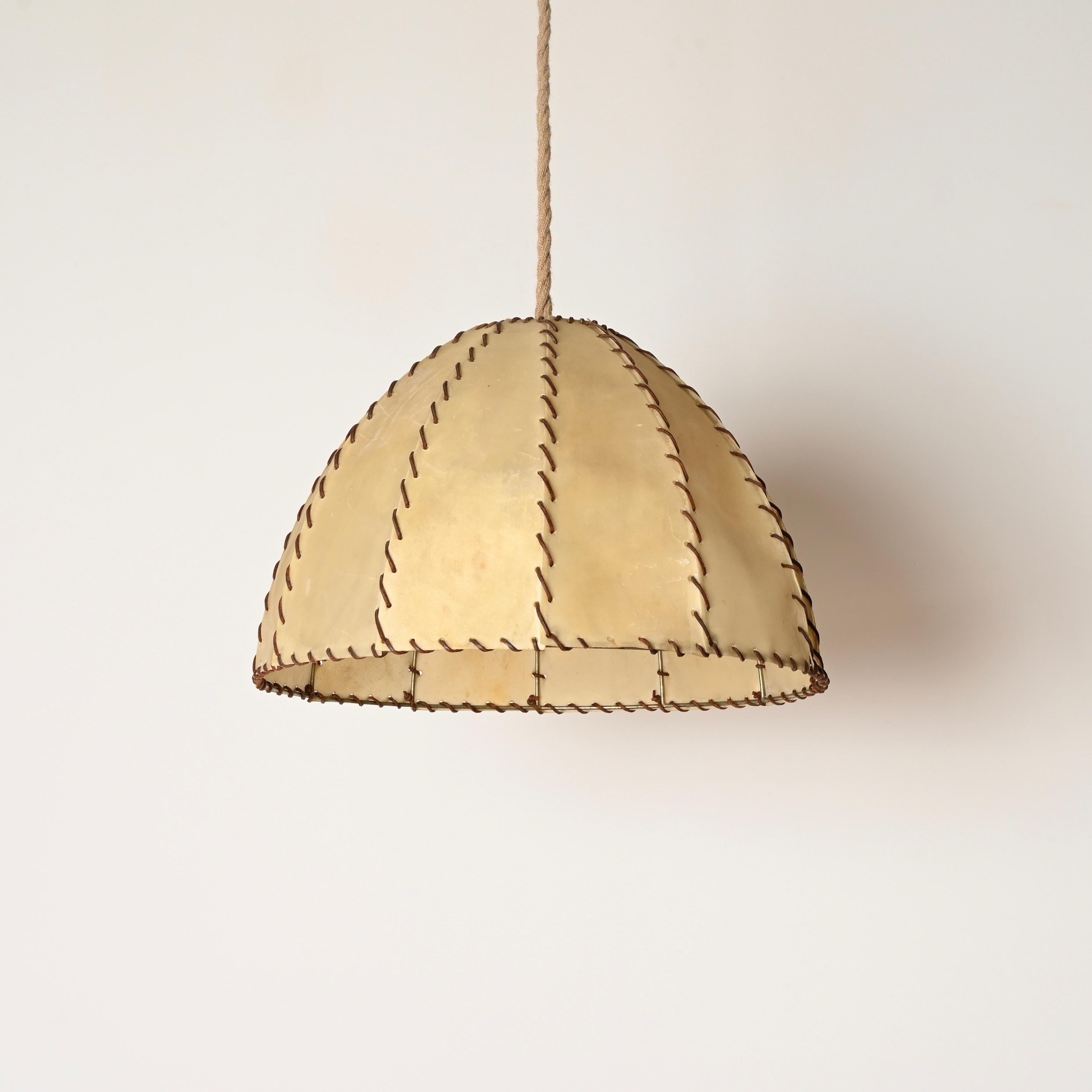 Superbe paire de lustres fabriqués à partir d'un beau mélange de parchemin et de détails en cuir noué, complétés par un cordon de corde et un baldaquin. Ces charmants et incroyablement rares lustres organiques ont été fabriqués en Italie dans les