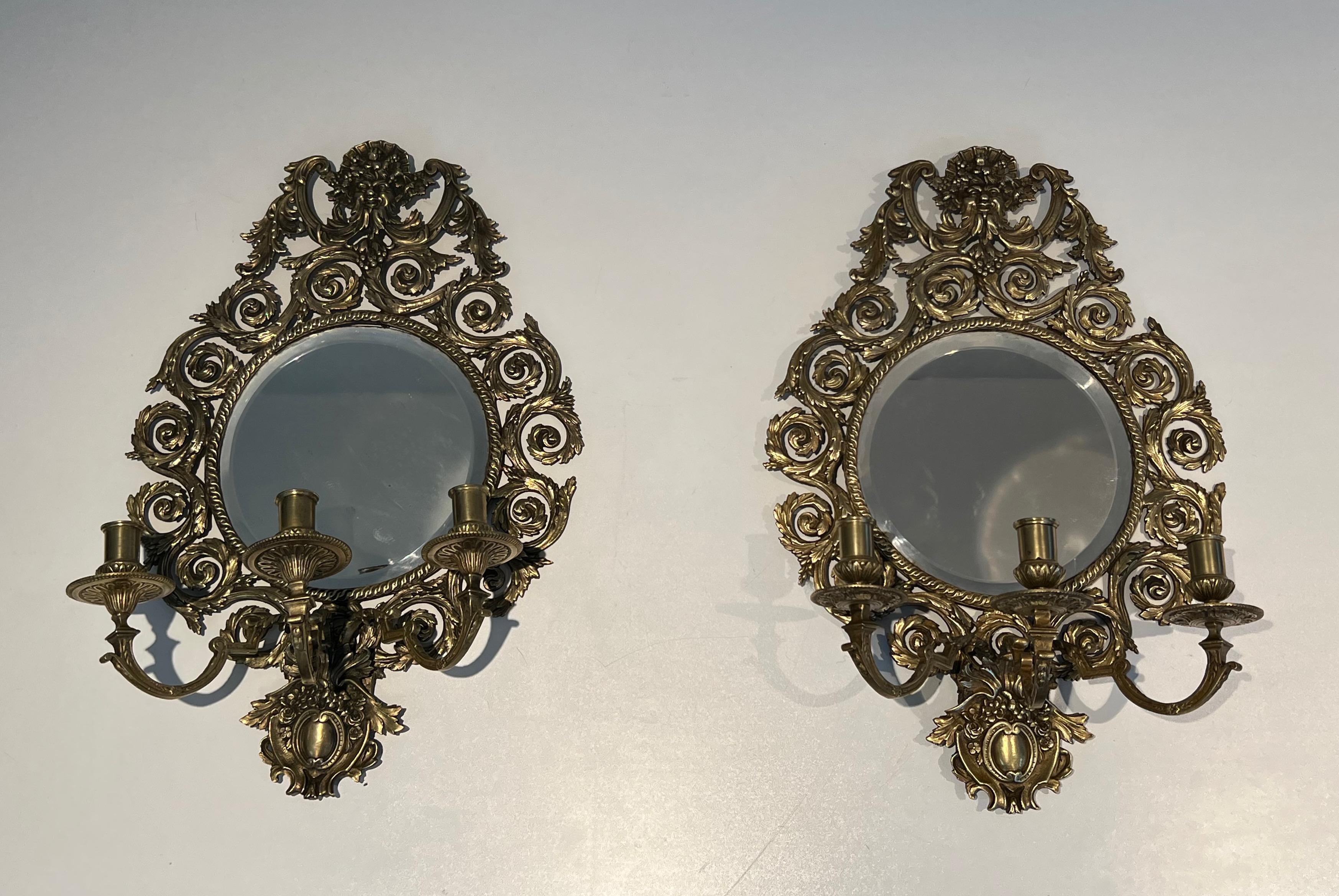 This very nice large pair of 3 arms Louis the 14th wall lights is made of chiseled bronze with a mirror on its center. These sconces ar every impressive and the quality is really fine; This is a French work. End of 19th century, circa 1880.