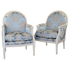 Grande paire de chaises Bergere en bois laqué de style Louis XVI