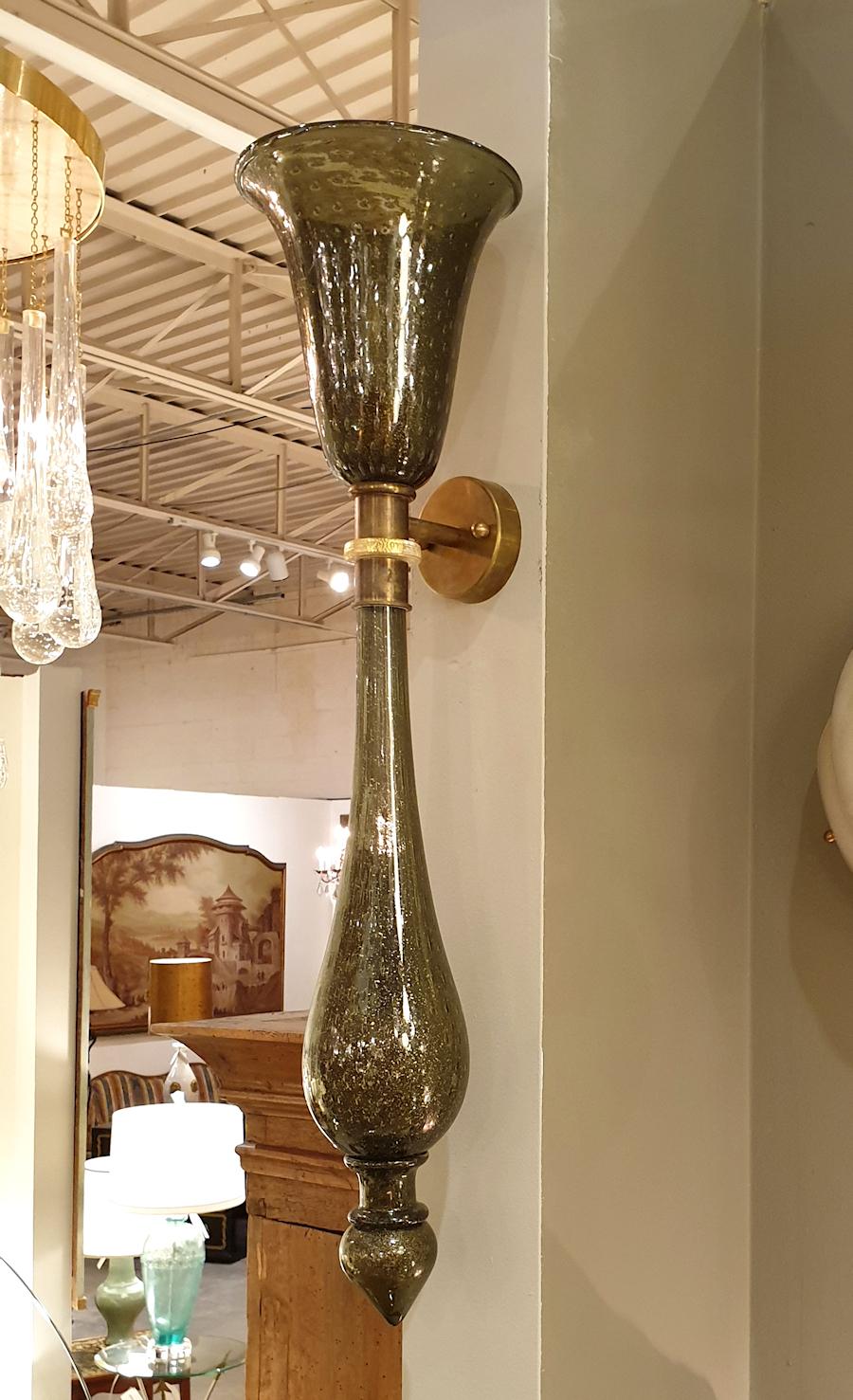 Pair of large torchère wall sconces, in hand blown gray Murano glass, with brass fittings.
They have 1 light each, and have been rewired.
Bullicante decor of the glass: air bubbles circled by gold leaf, inside the glass.
Some gold flakes give a