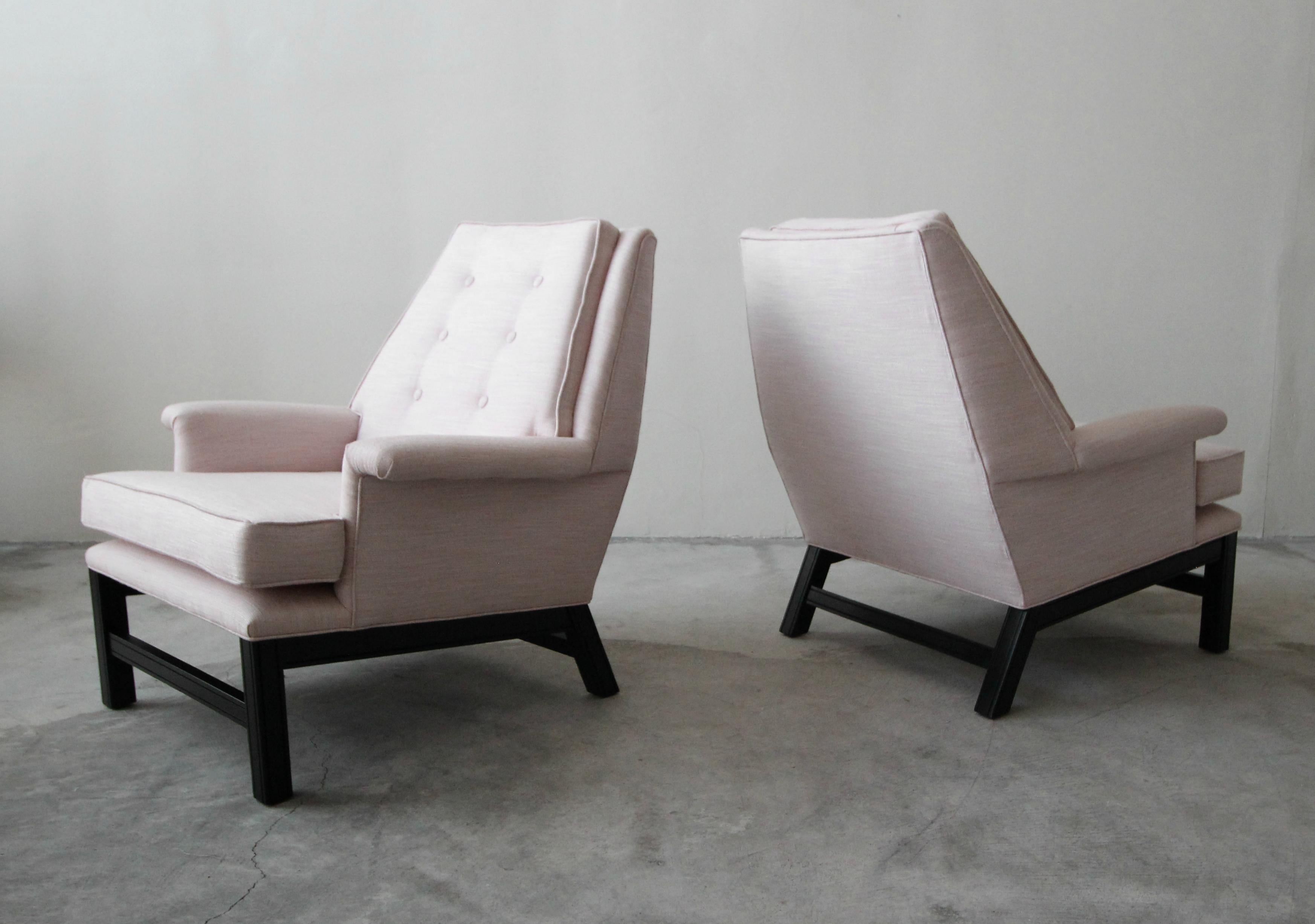 Absolutely stunning pair of midcentury lounge chairs. These chairs are wonderfully sized with a beautiful stature. The black bases create stunning contrast against the pale pink fabric.

The bases are solid and in good condition. The chairs have