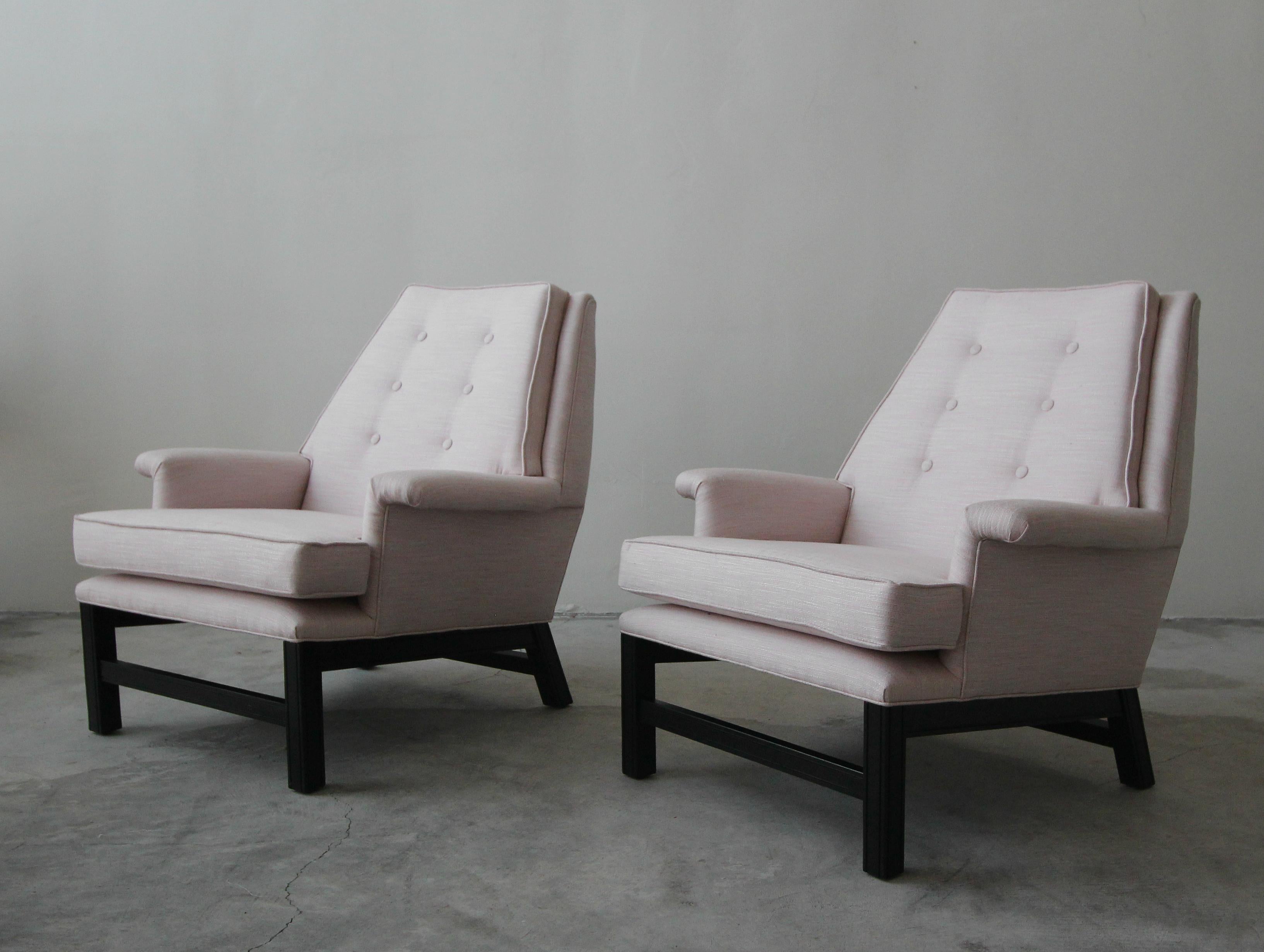 Absolutely stunning pair of midcentury lounge chairs. These chairs are wonderfully sized with a beautiful stature. The black bases create stunning contrast against the pale pink fabric.

The bases are solid and in good condition. The chairs have