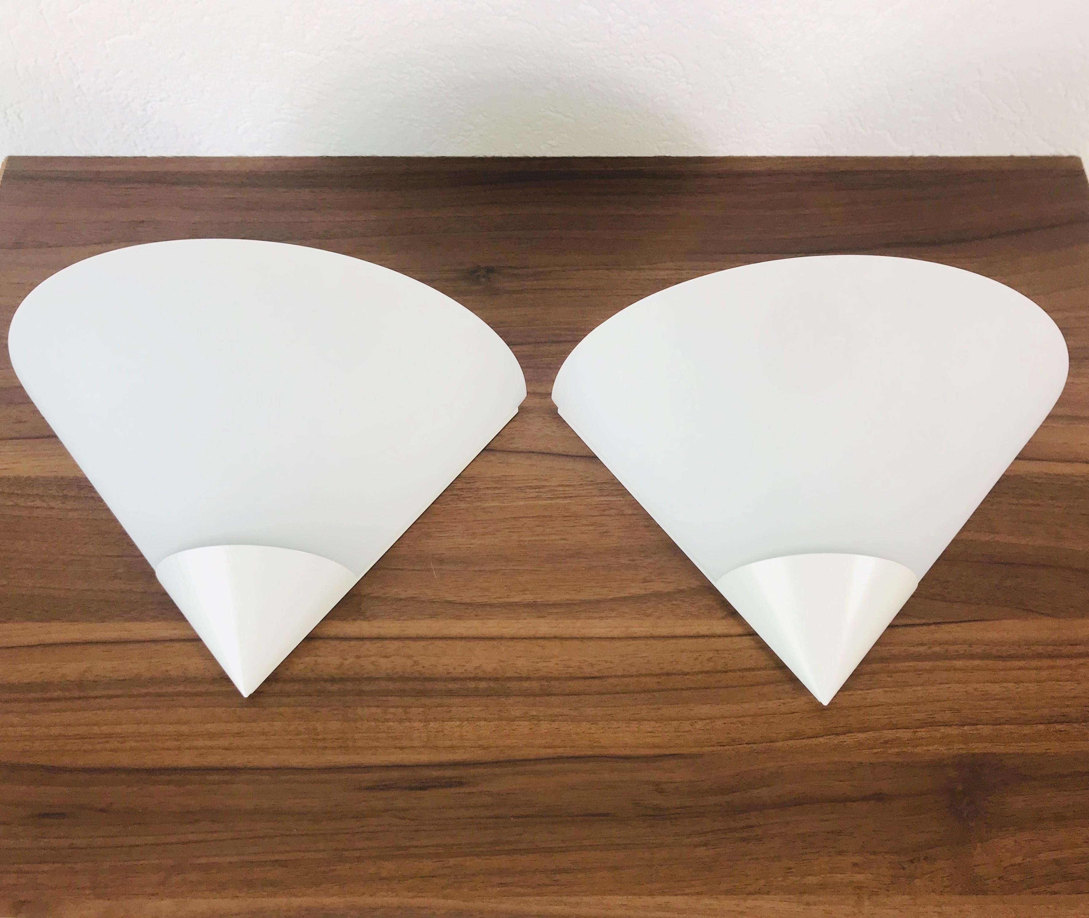 Preciosa pareja de apliques de la modernidad de mediados de siglo de Glashütte Limburg, fabricados en Alemania en la década de 1970. Tiene una bonita forma triangular y está hecha de aluminio y cristal opalino. La parte trasera es de metal