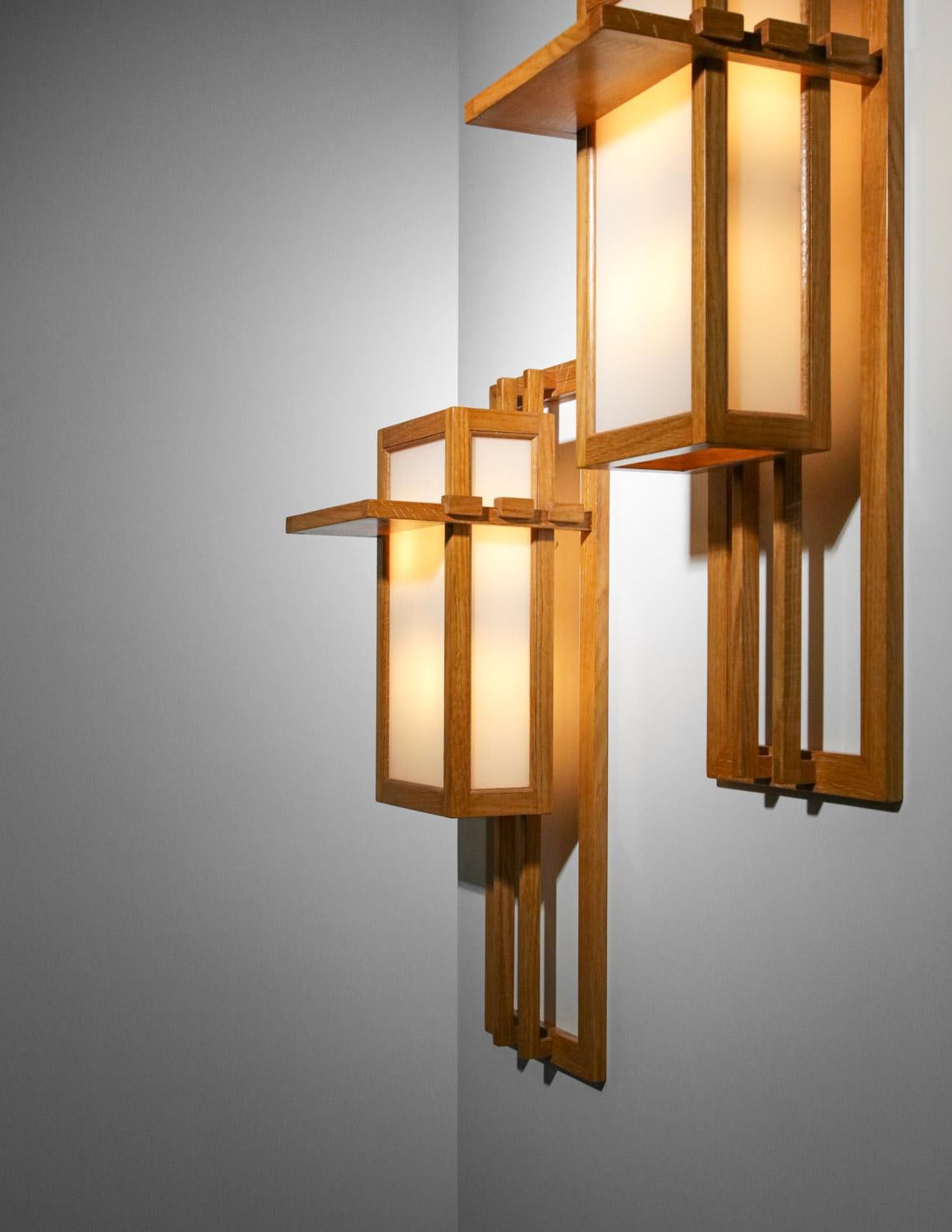 Large pair of modernist sconces from the 50's in the style of Frank Lloyd Wright's work. Structure of the wall sconces in light solid wood and diffusers in white opaque glass. Sober and pure design for very decorative sconces. Very nice vintage