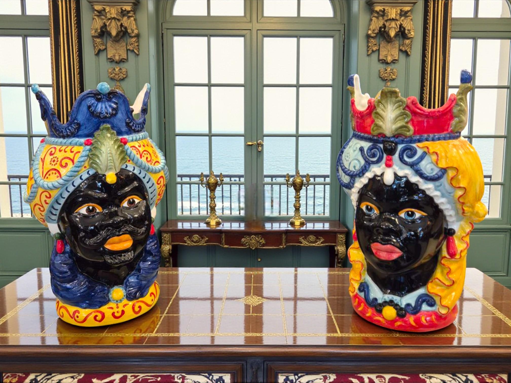 This remarkable pair of Moorish heads, entirely handcrafted in Bassano, Italy, embodies the traditional mastery of Italian ceramics. Their expressive modeling, lustrous glazing, and rich color palette — cobalt blue, deep red, and saffron yellow —