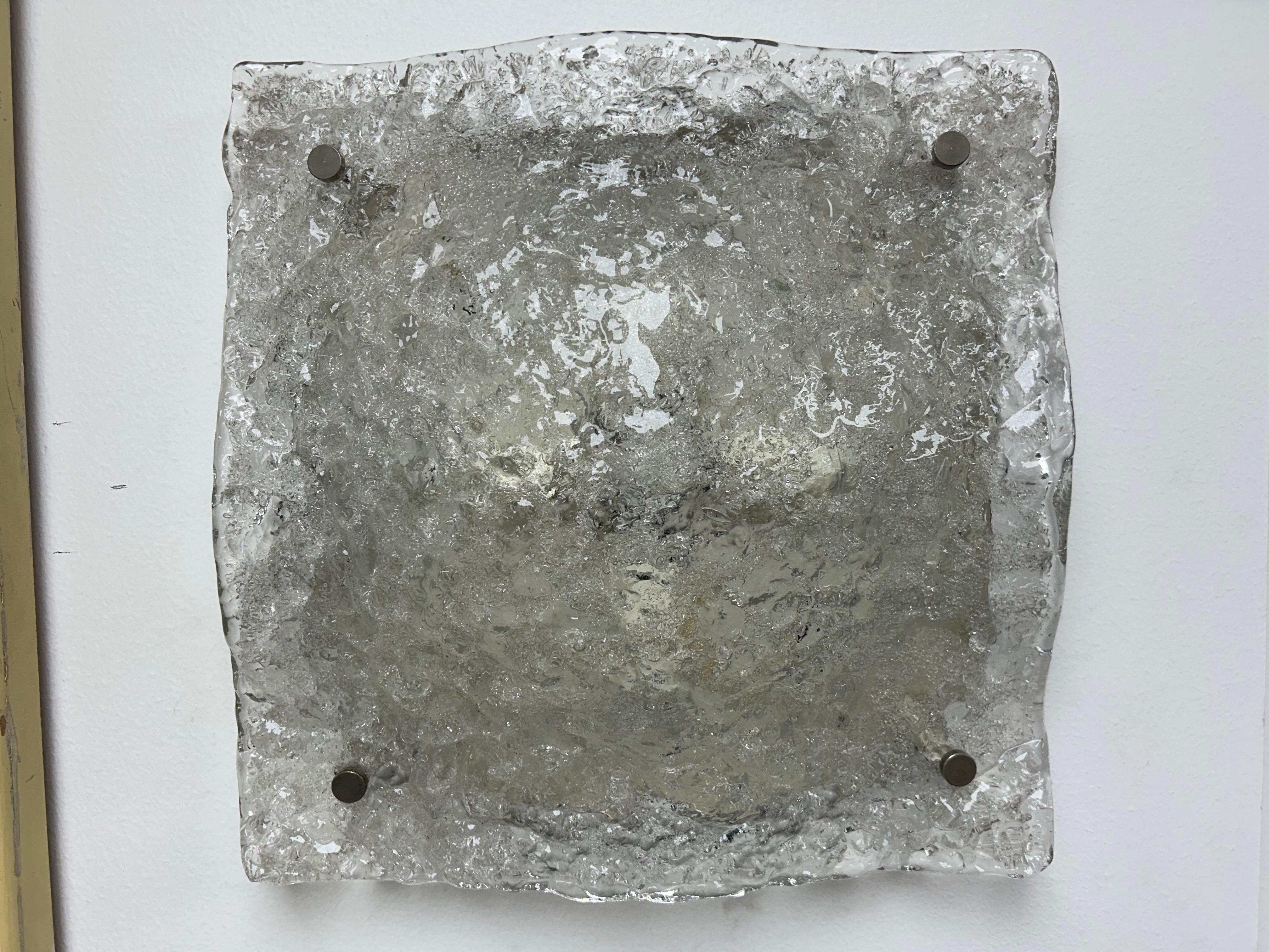 Large Pair Of Murano Glass Sconces By Mazzega.
Offered is a stunning pair of Italian mid century glass sconces designed by Carlo Nason for Mazzega. These square clear textured blown glass sconces are mounted on steel frames and have been newly wired